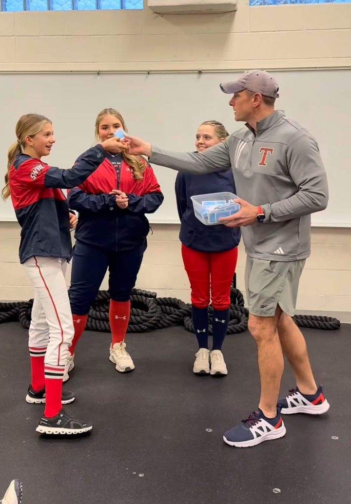 Coach Davie hands out raffles as the softball team celebrates hard work.