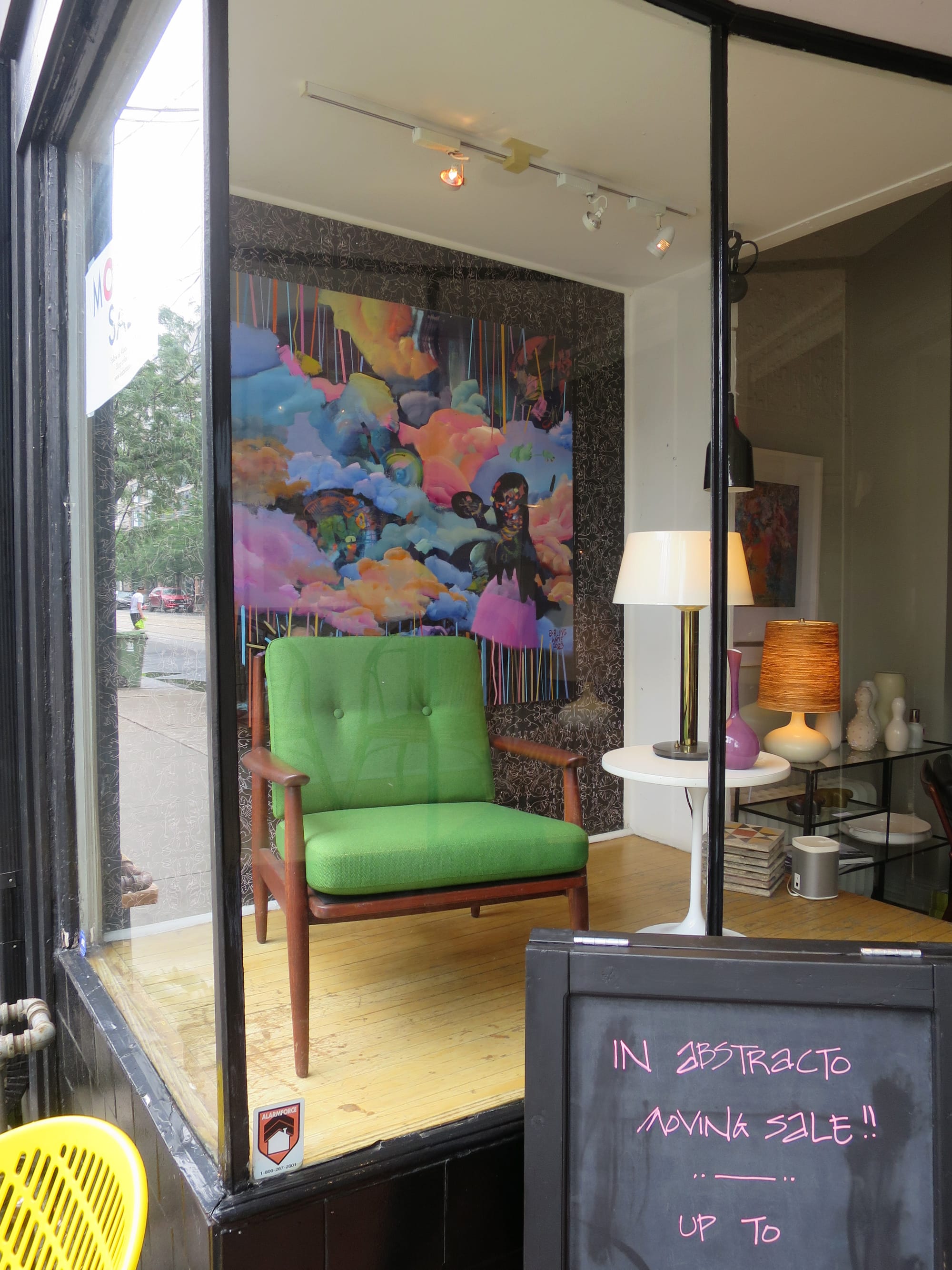 One of the inabstracto windows showing an armchair, side table, lamp, vase and painting.