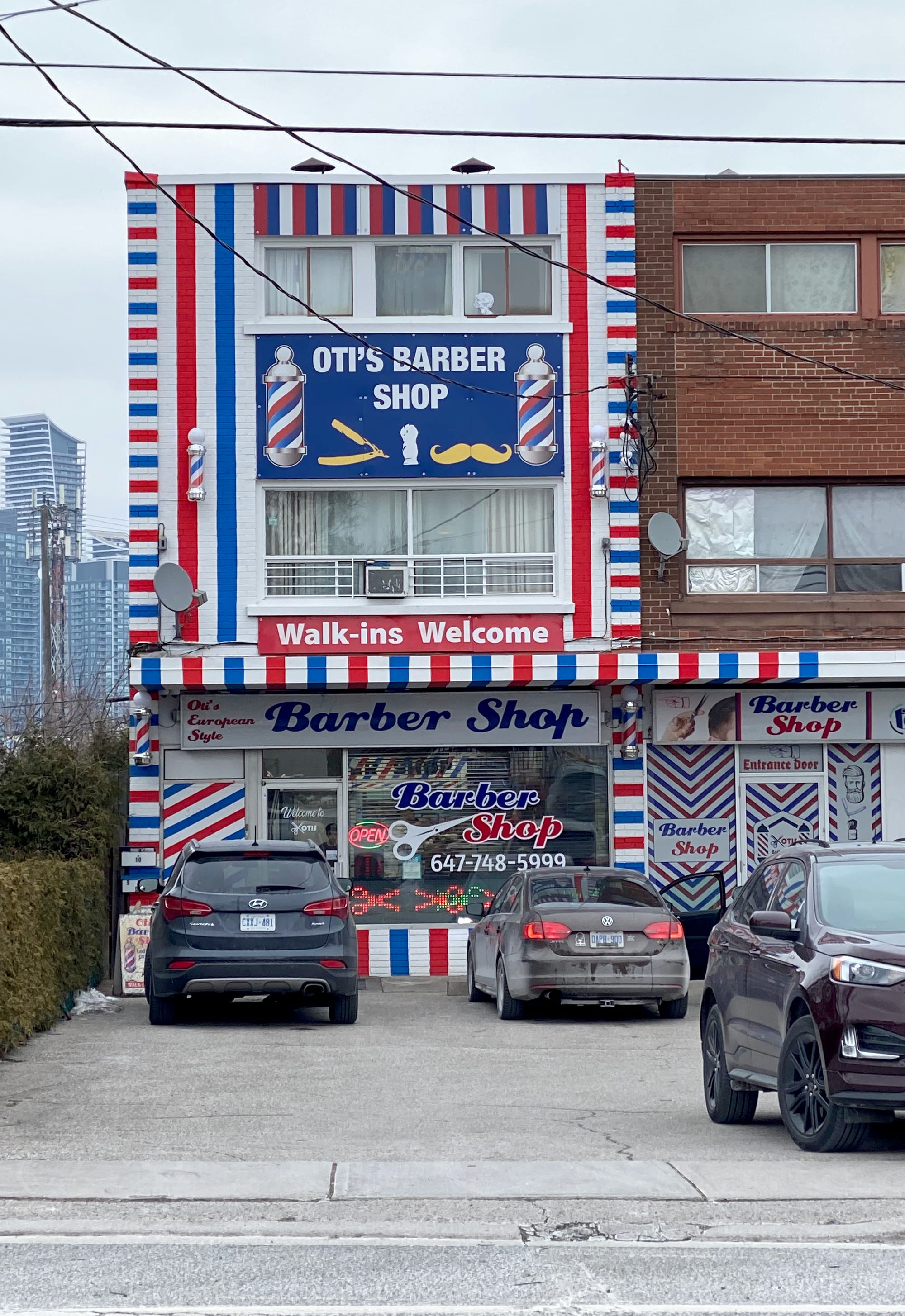 Barber shop with blue, white, and red stripes all over its façade.
