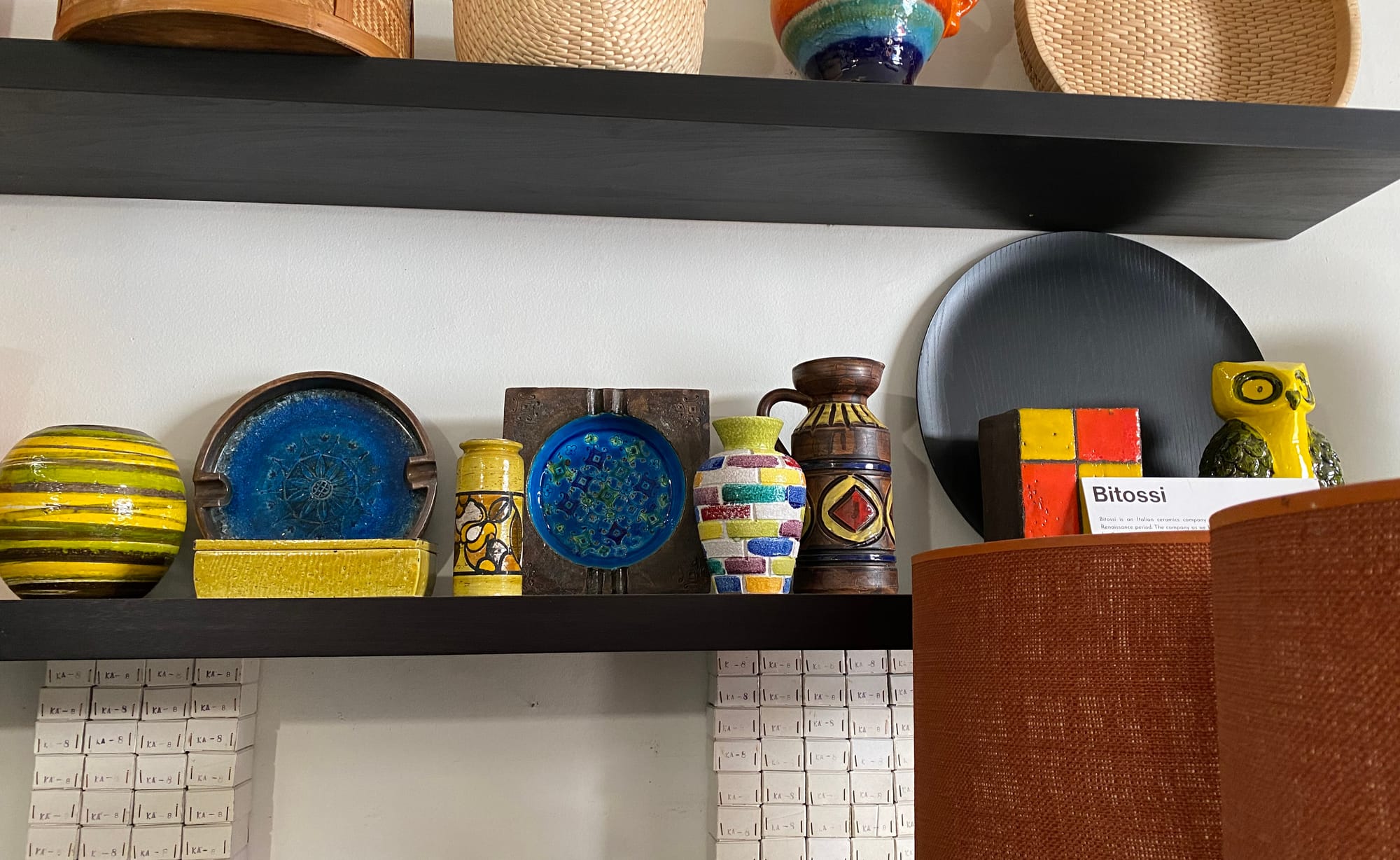Collection of Bitossi ceramics on a long shelf.