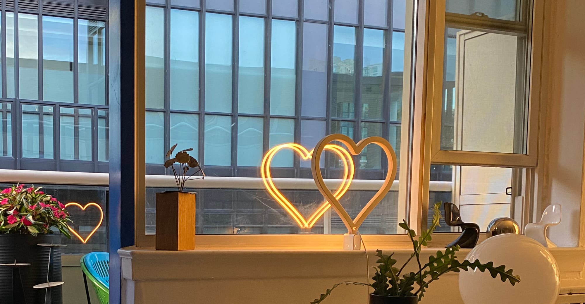 Windowsill with neon heart and other decorative items.