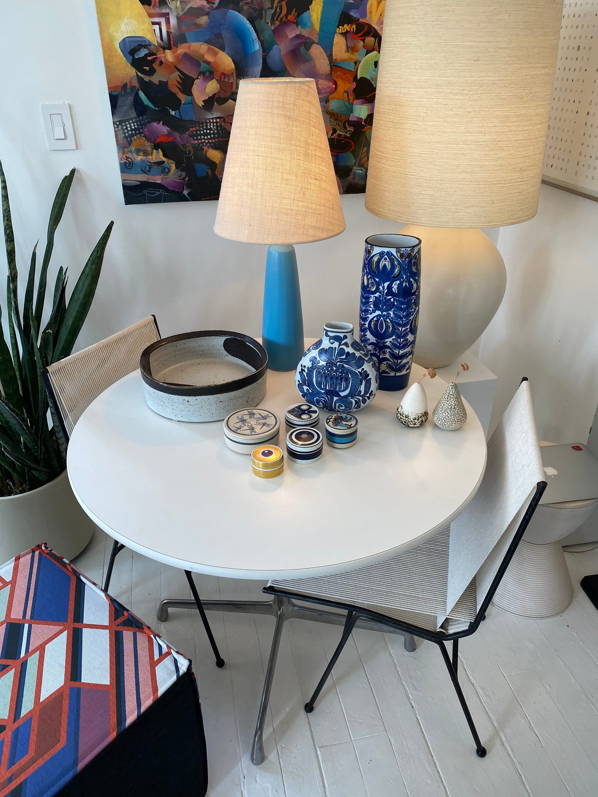 Dining table displaying assorted objects, including five porcelain trinket boxes.
