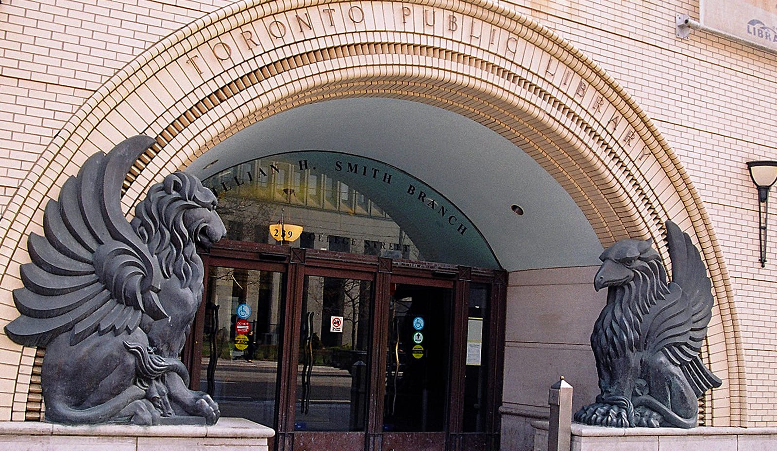 Entrance to a branch of Toronto Public Library, with a mythological creature on each side.