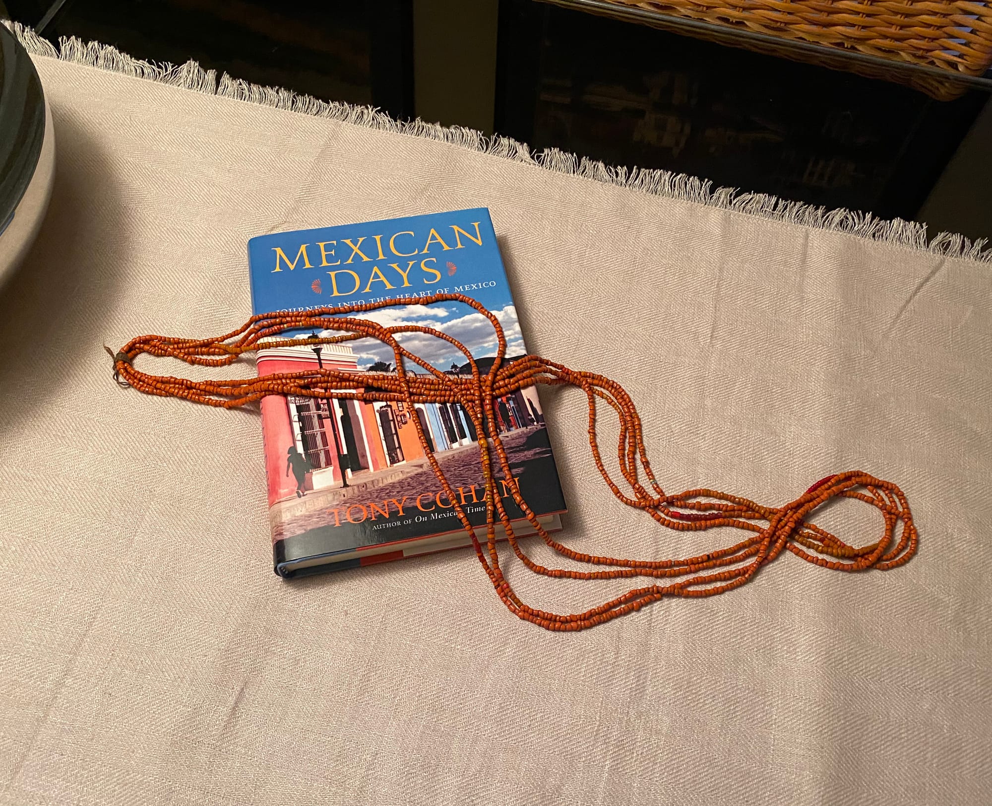 Strands of beads draped over a book called Mexican Days.