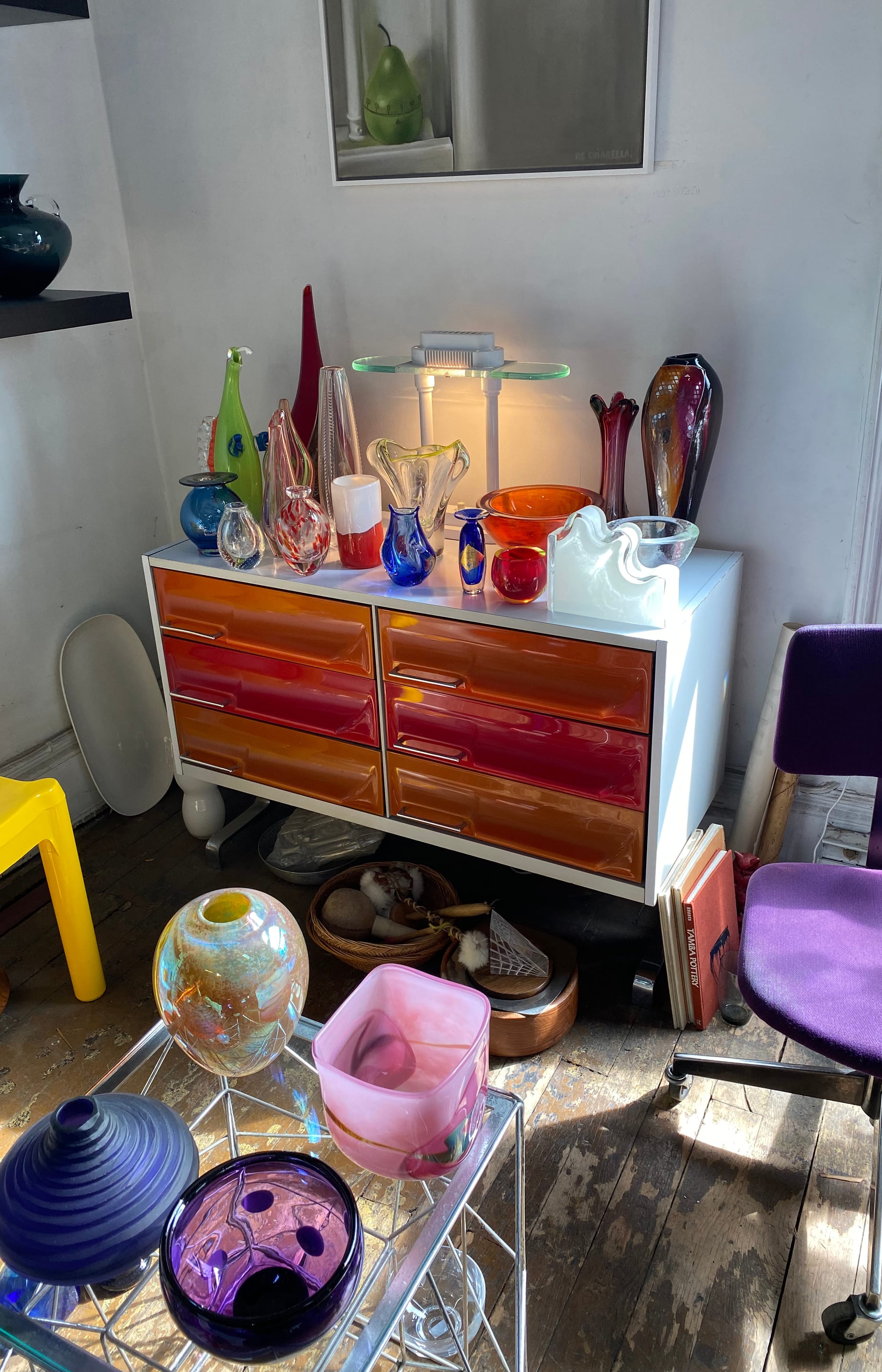 Six-drawer dresser with assorted glass objects on top.