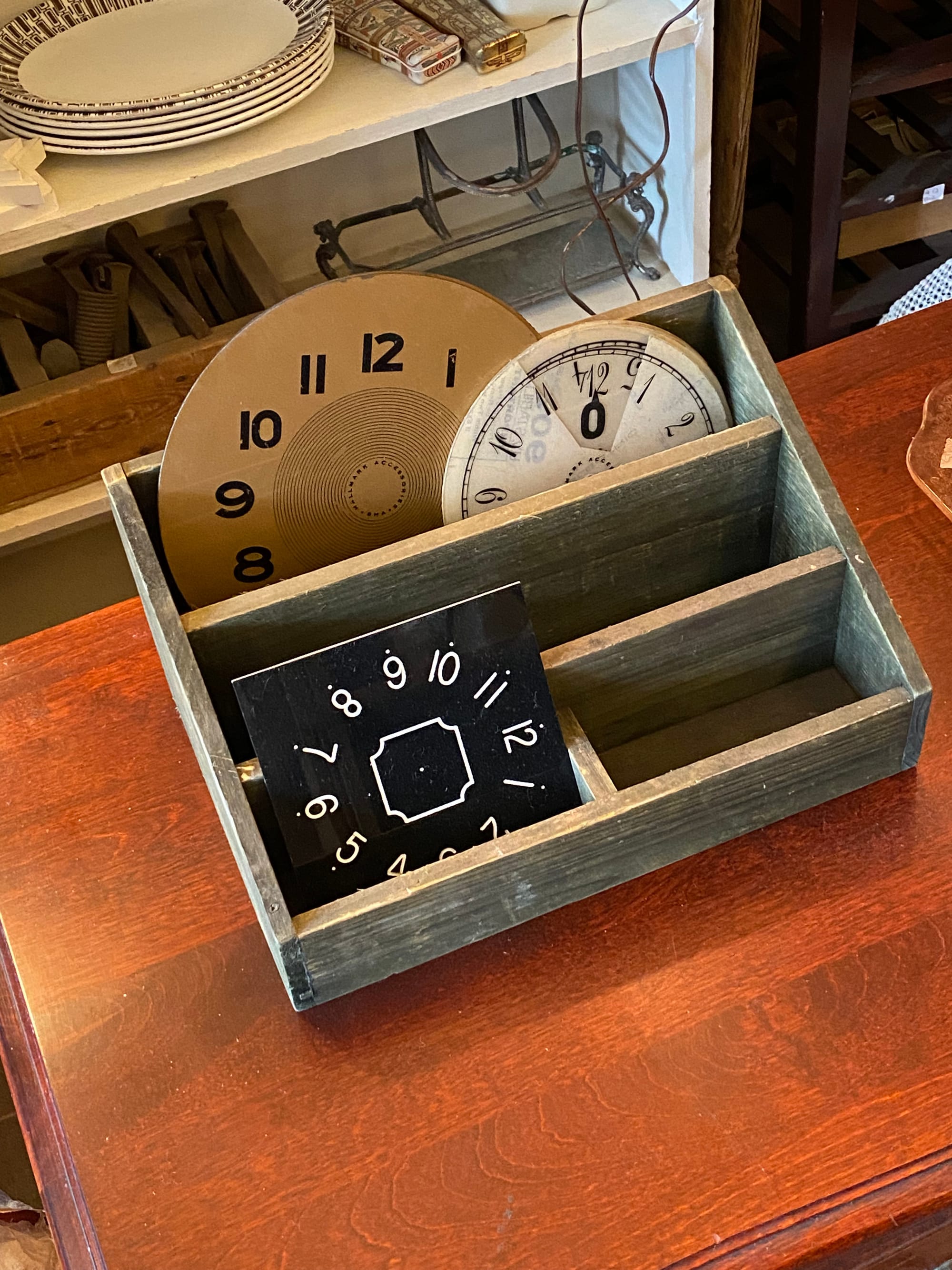 Wooden desk organizer holding several clock faces.