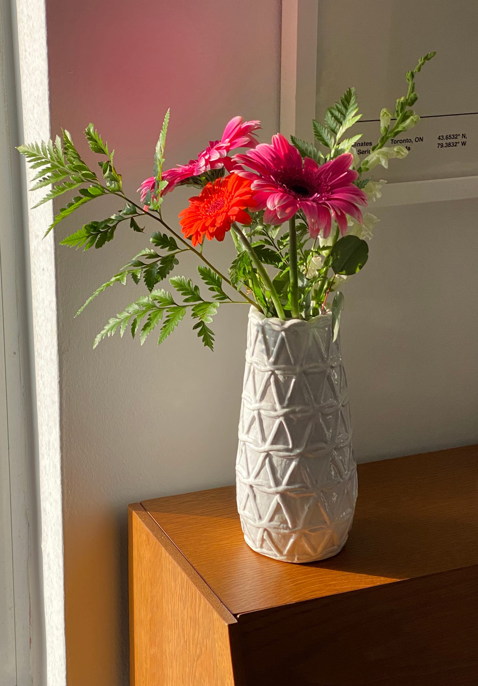 The same three Gerbera daisies as before, this time held in a more traditional vase.