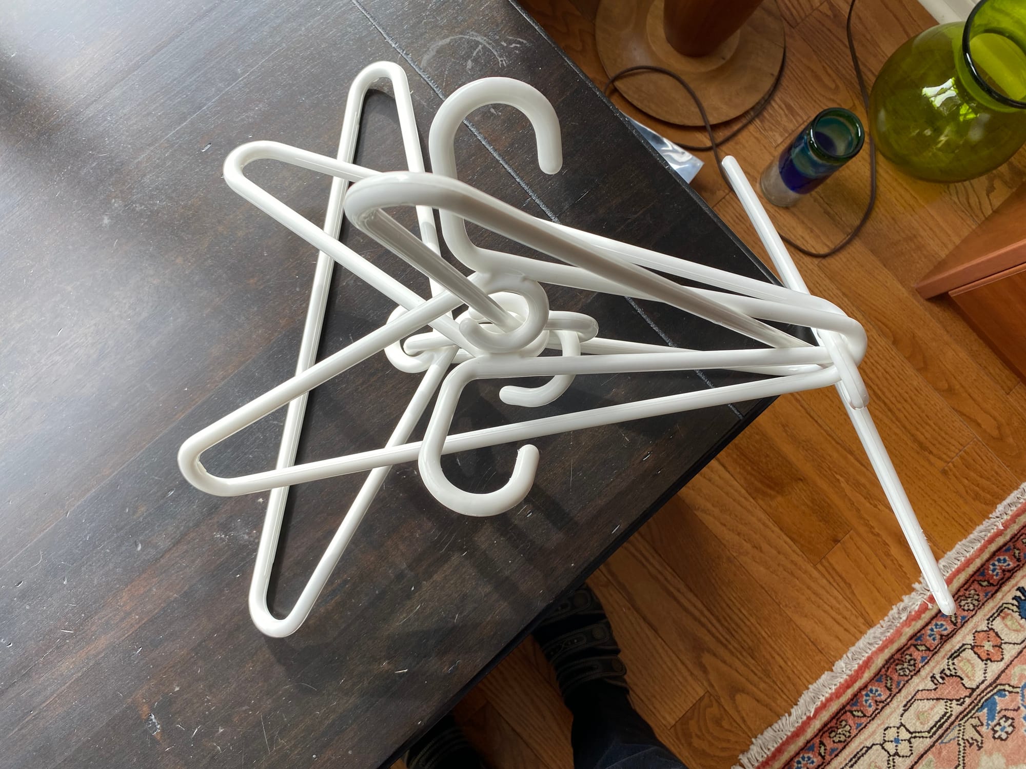 White plastic hangers arranged in an interlocking sculptural manner.