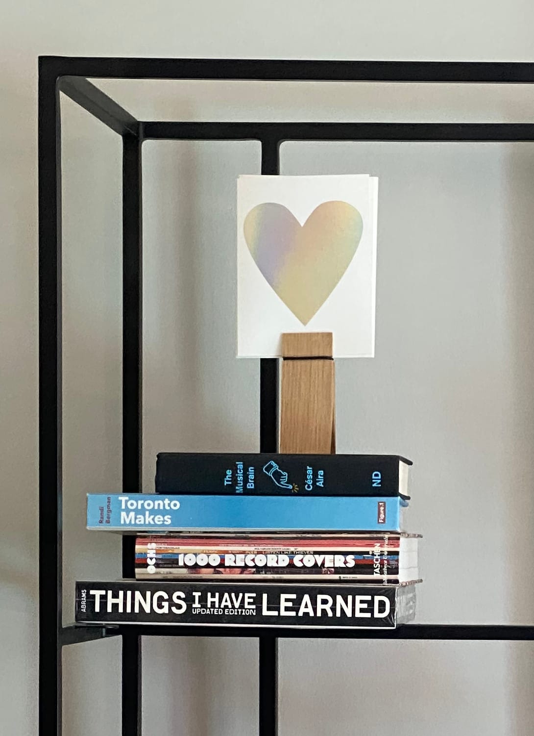 Stack of four books, the left edge jagged due to varying book sizes.