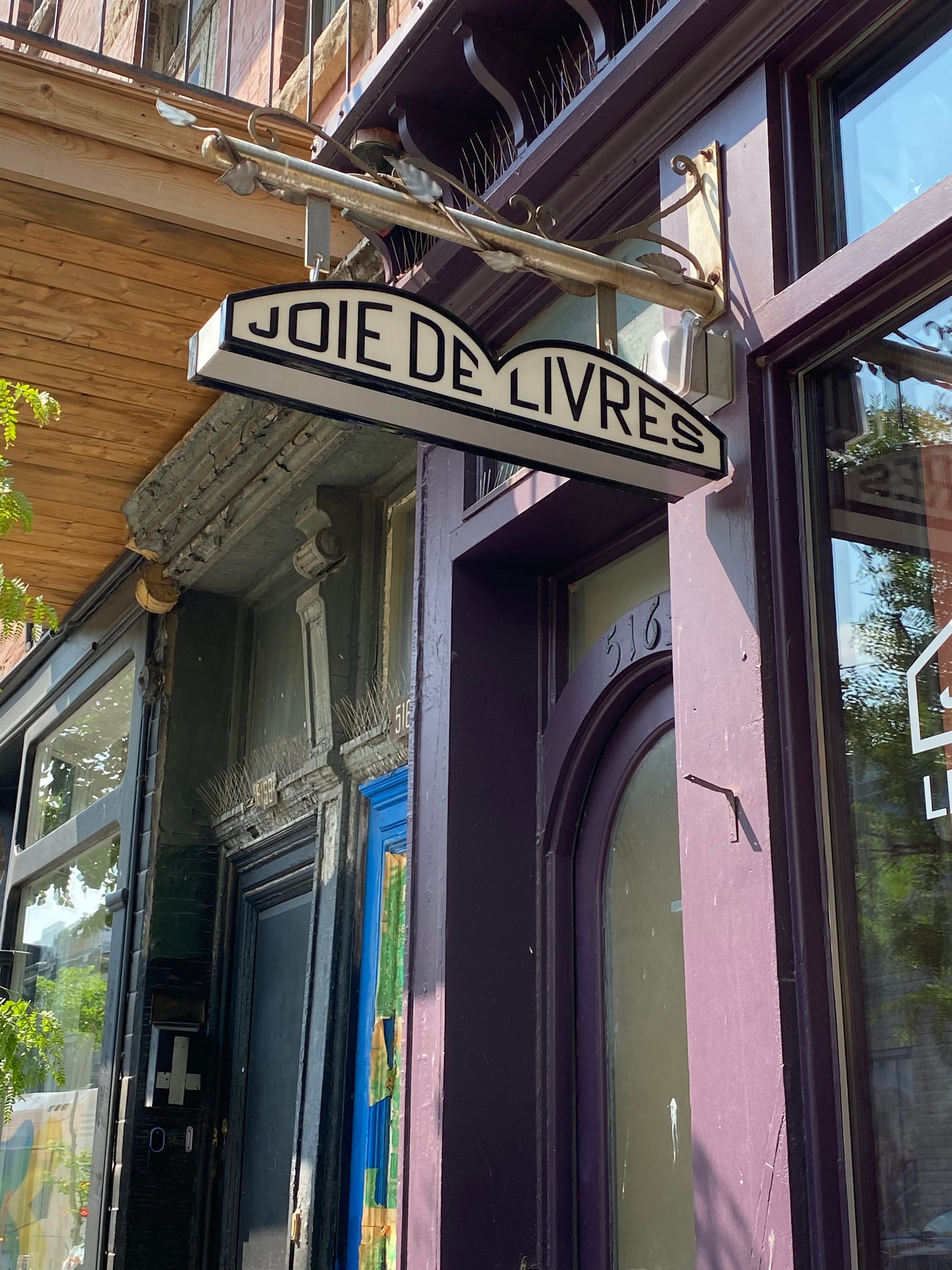 The Joie de Livers sign, with the letters of the store name contained in the silhouette of an open book.