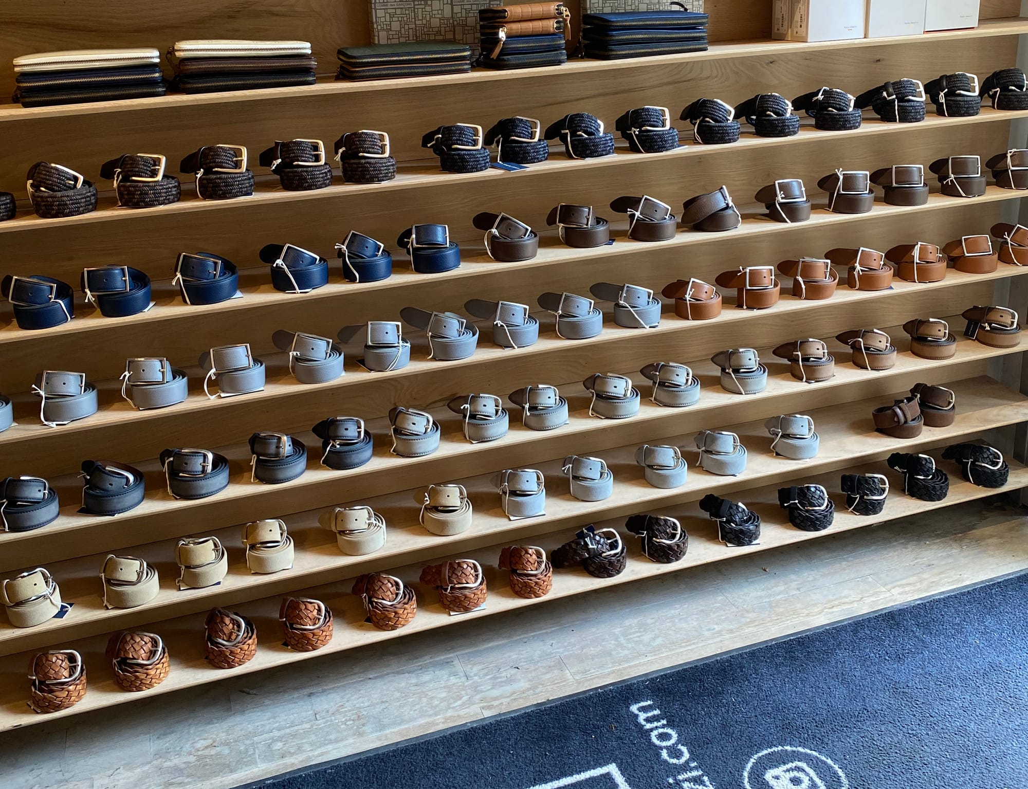 Wide shot of belts neatly curled in spiral formations and arranged on shelves.