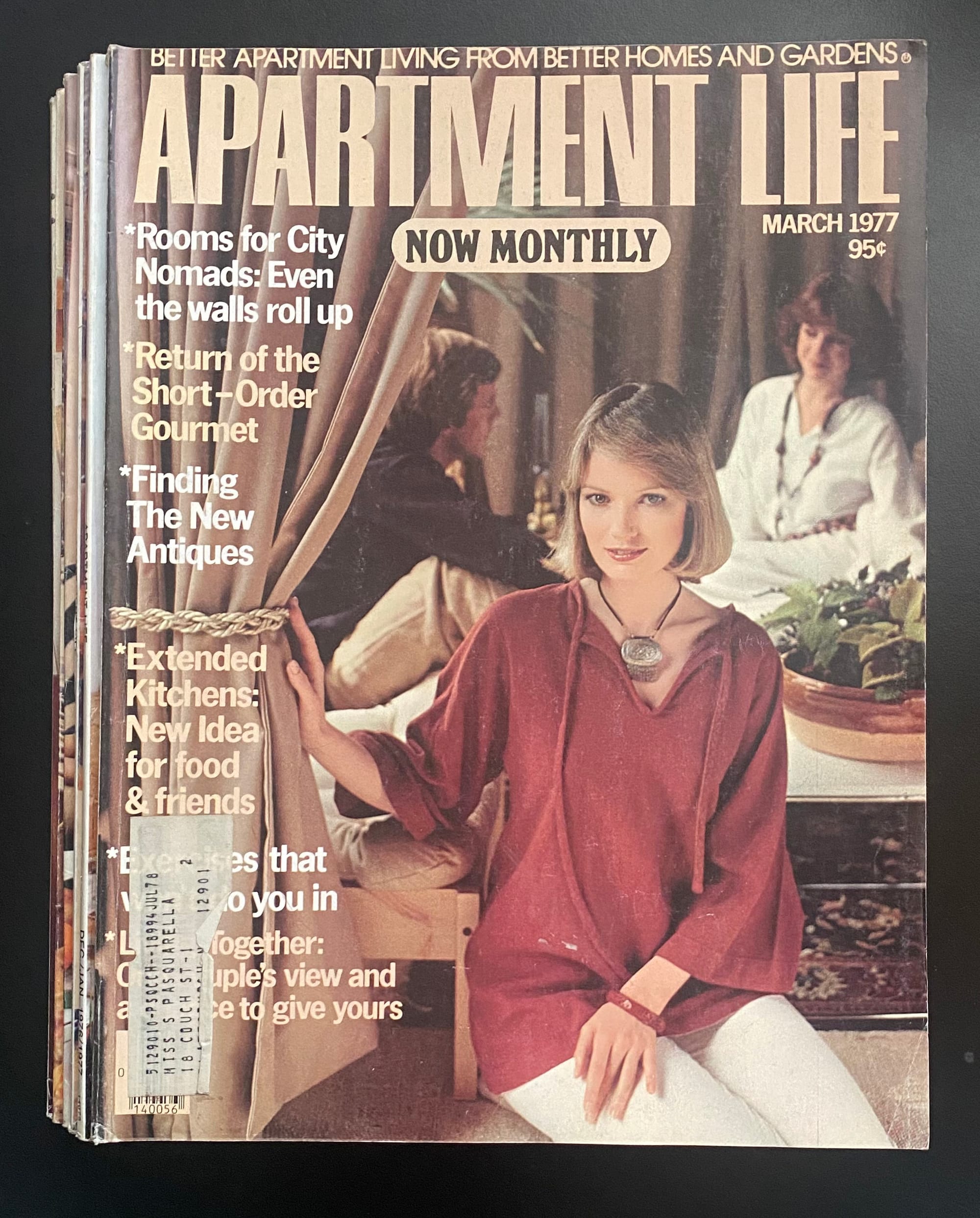 Two women and a man relaxing in a drapery-clad room.