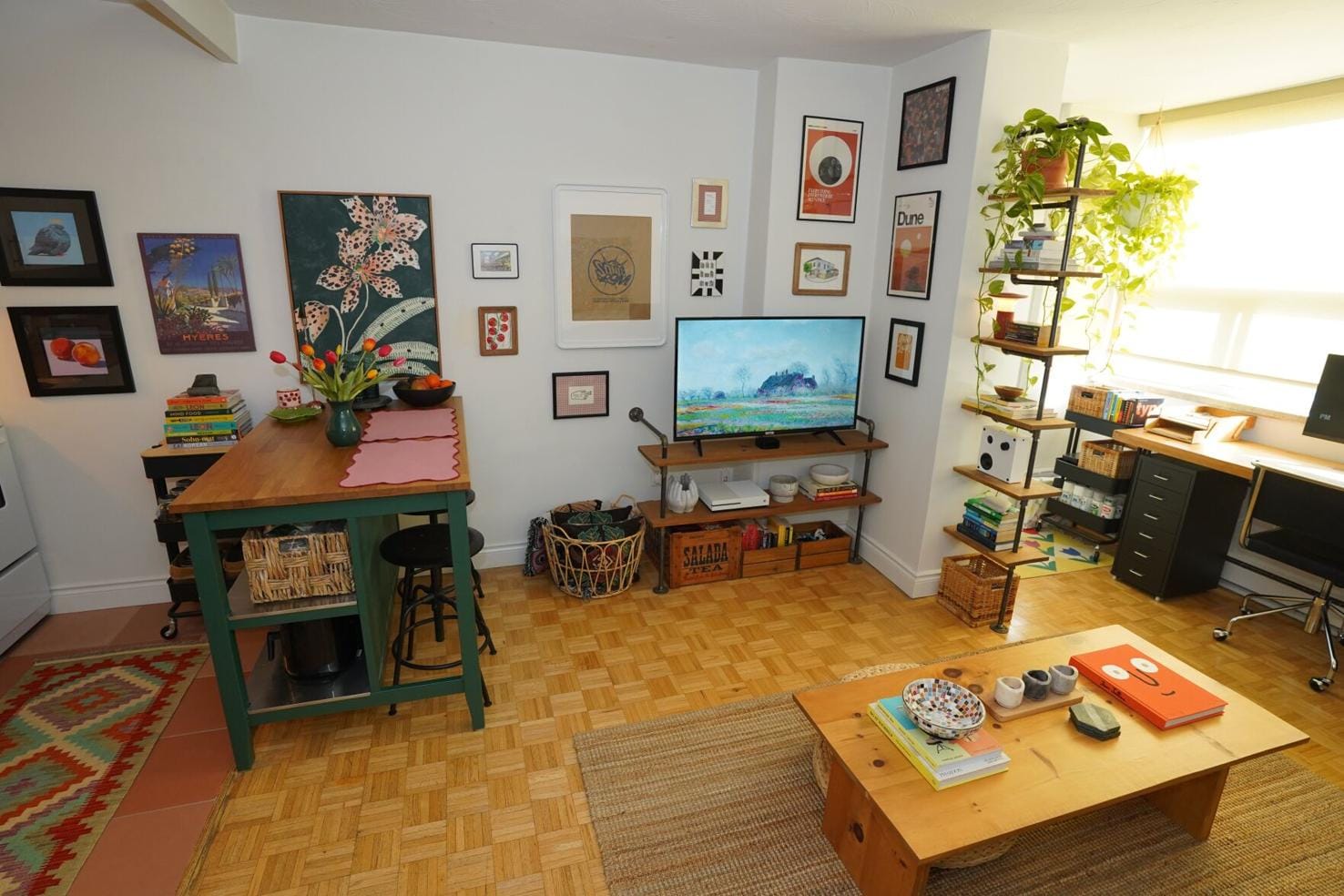 Compact and well-organized space with a wall full of framed artwork.