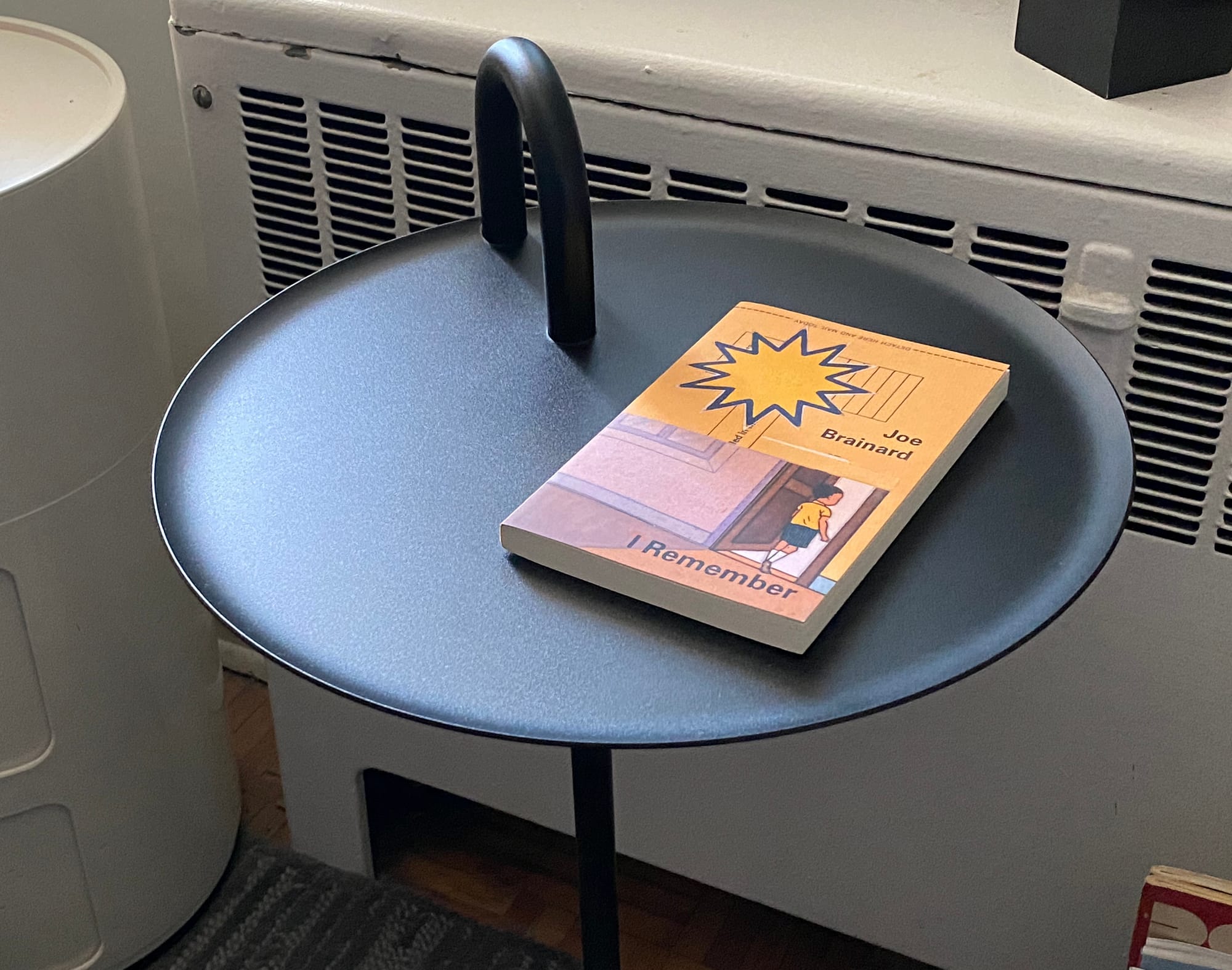 Surface of Bowler side table featuring the book "I Remember" by Joe Brainard.