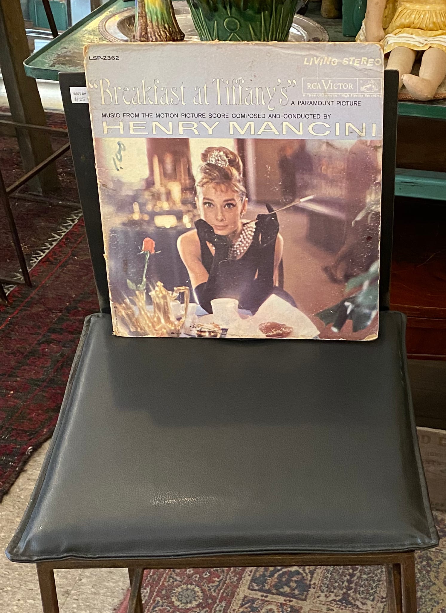 A vinyl record, the score of Breakfast at Tiffany's, on a chair. The cover features a photo of Audrey Hepburn in her role as Holly Golightly.