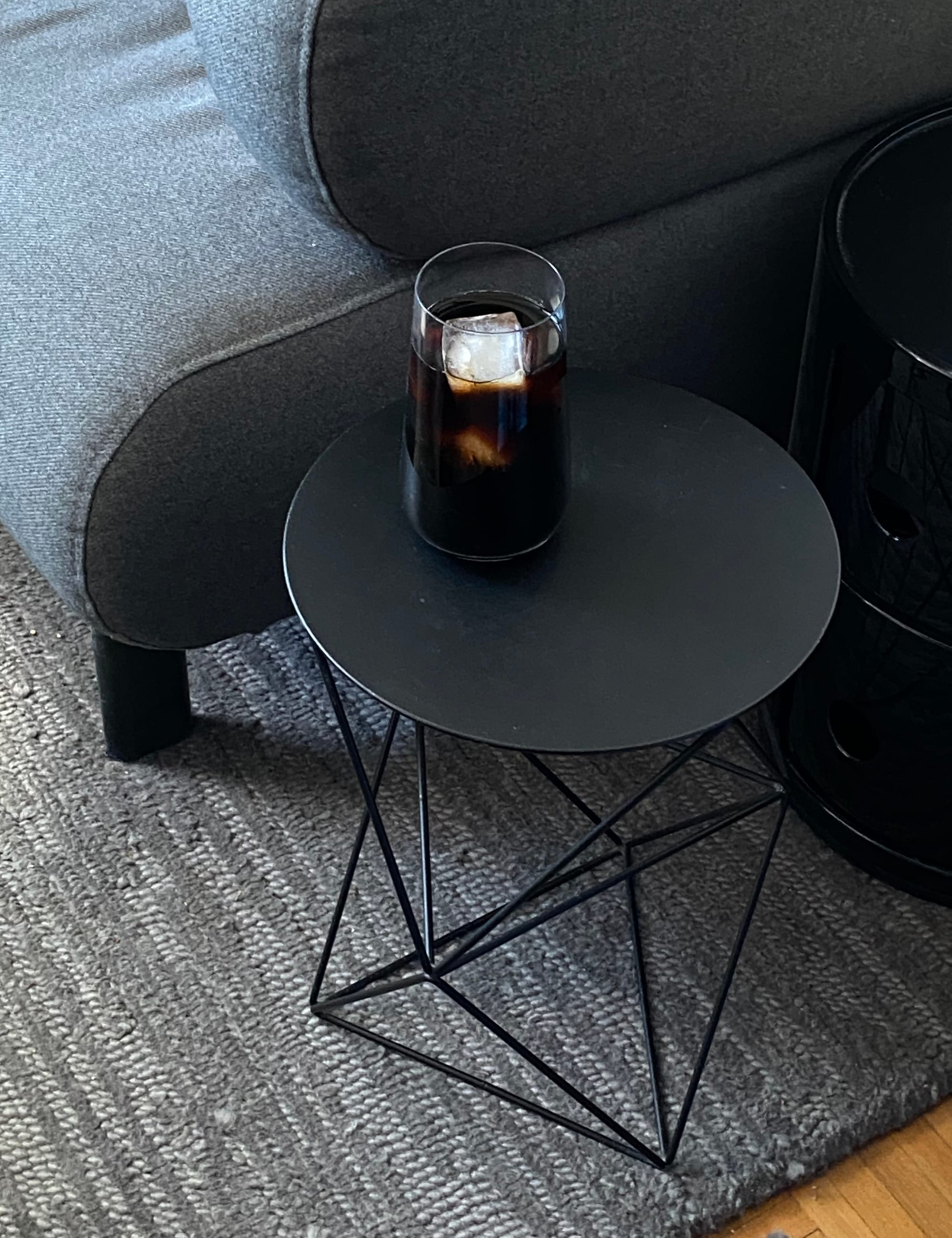 Cold brew in a glass resting on a small side table.