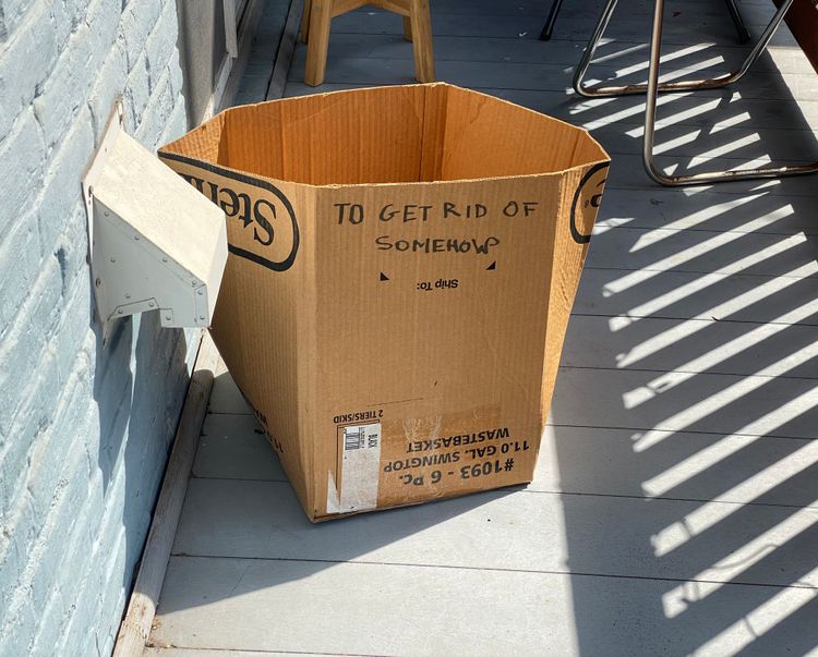 cardboard box with writing on the side that says "to get rid of somehow"