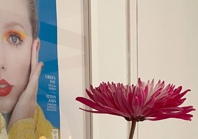 Close up of a flower with a framed image of Taylor Swift cropped on the left.