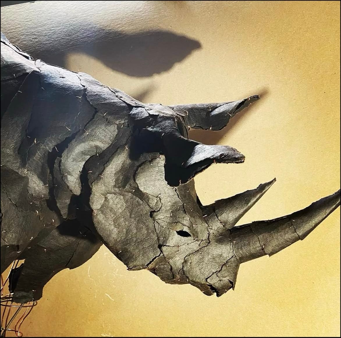 Sculpture of a Rhinoceros materials are attached as in a mosaic with staples.