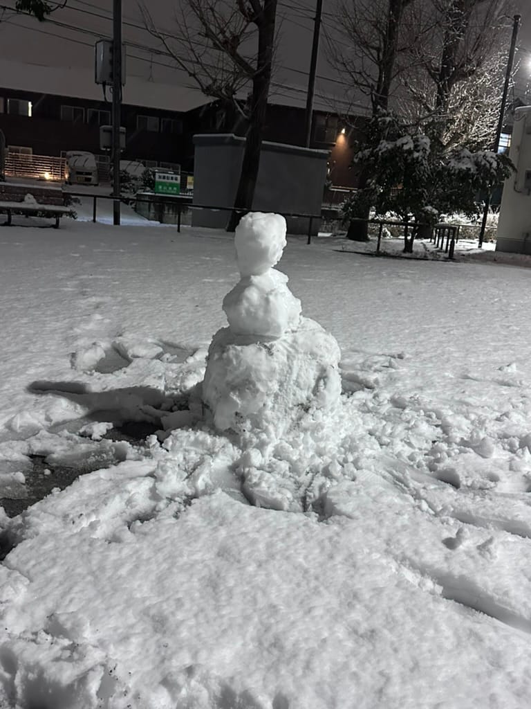 A poorly made snowan with 3 body segments in a park