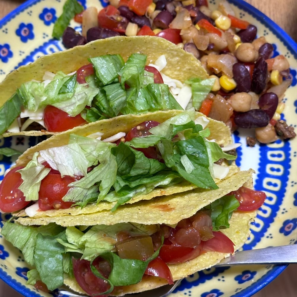 tacos with toppings and a side of beans