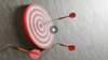 Red and white dartboard with 3 red darts - hit and misses