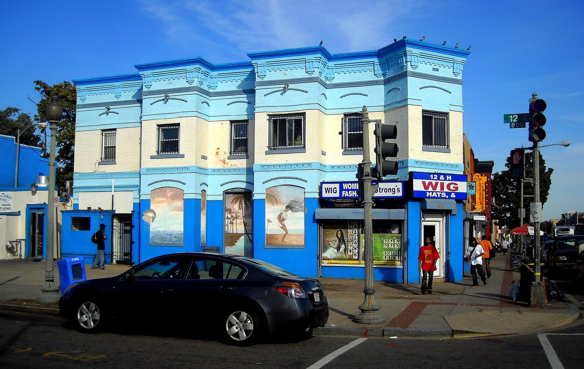Alt Text: A photo of a wig store in an blue building on a street corner in Washington D.C.'s Trinidad neighborhood.