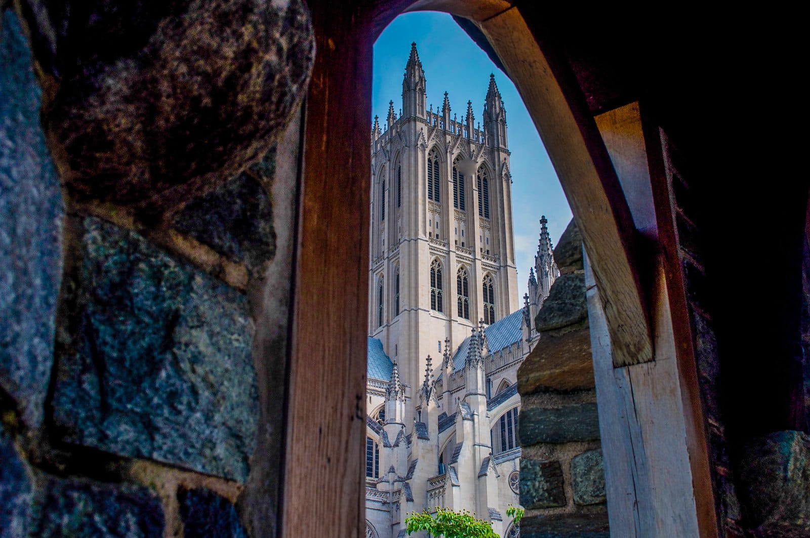 A large cathedral stands in the foreground, framed by an arched passageway.