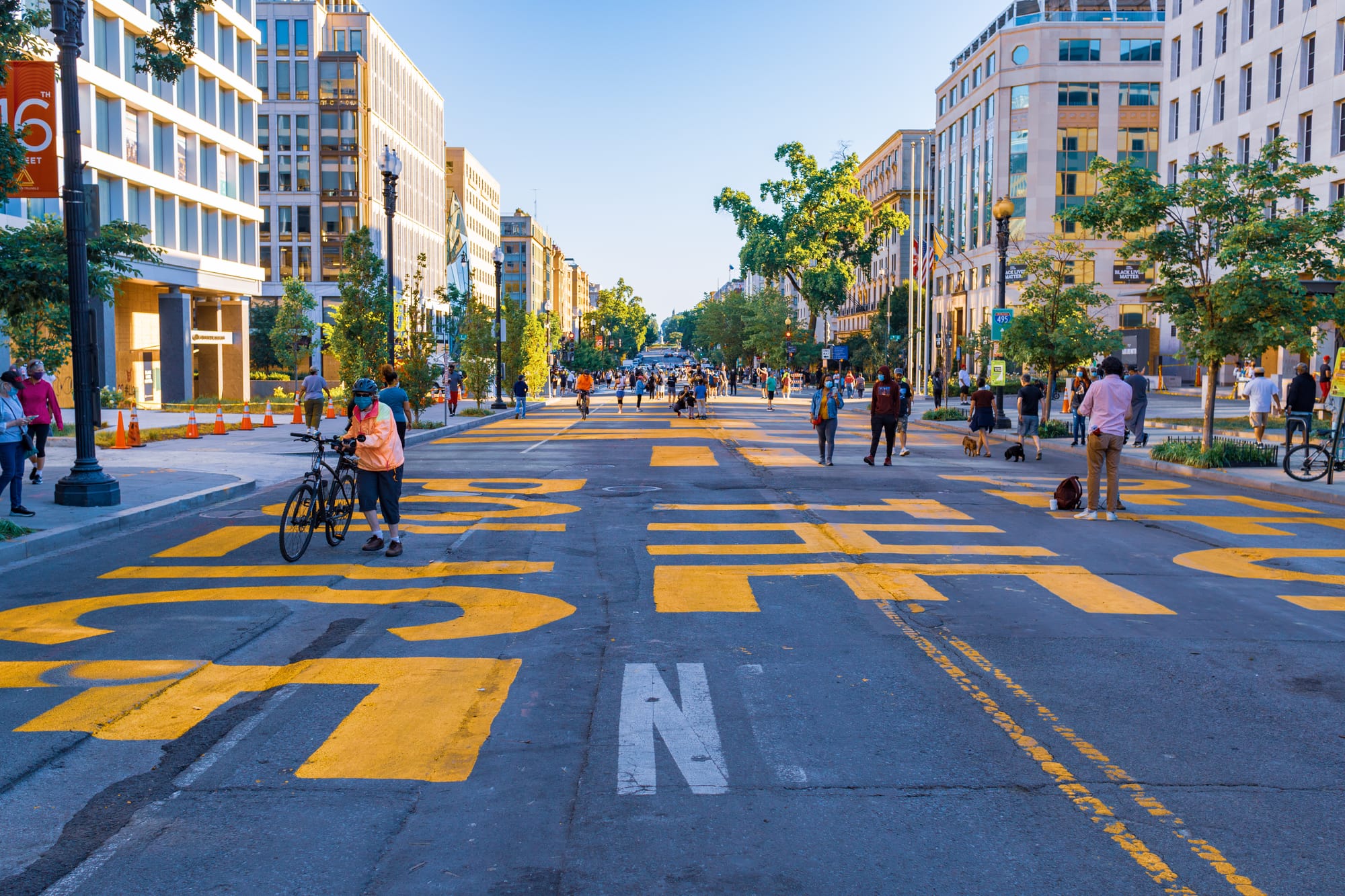 People walk over the plaza, which read Black Lives Matter = Defund the police