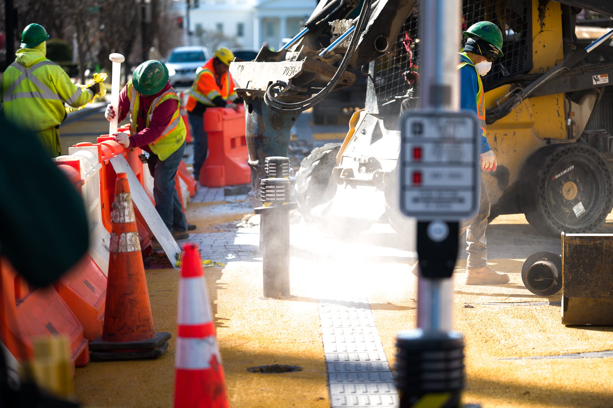 Drills and bulldozers work into the ground on the strip of blocks. 