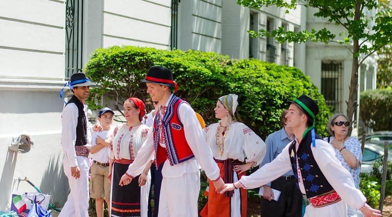 Photo of people holding hands, in motion, during a cultural celebration.