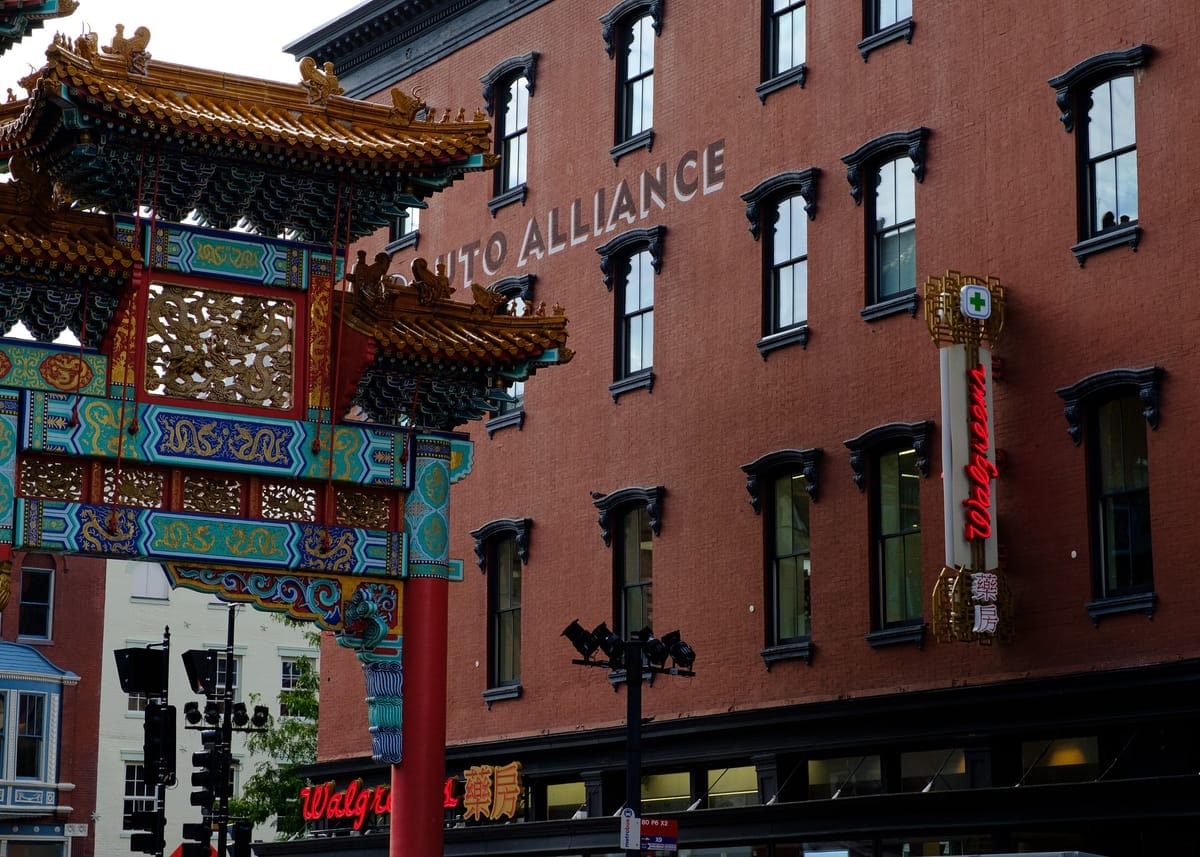 Chinatown arches slightly out of frame next to a red brick building. 