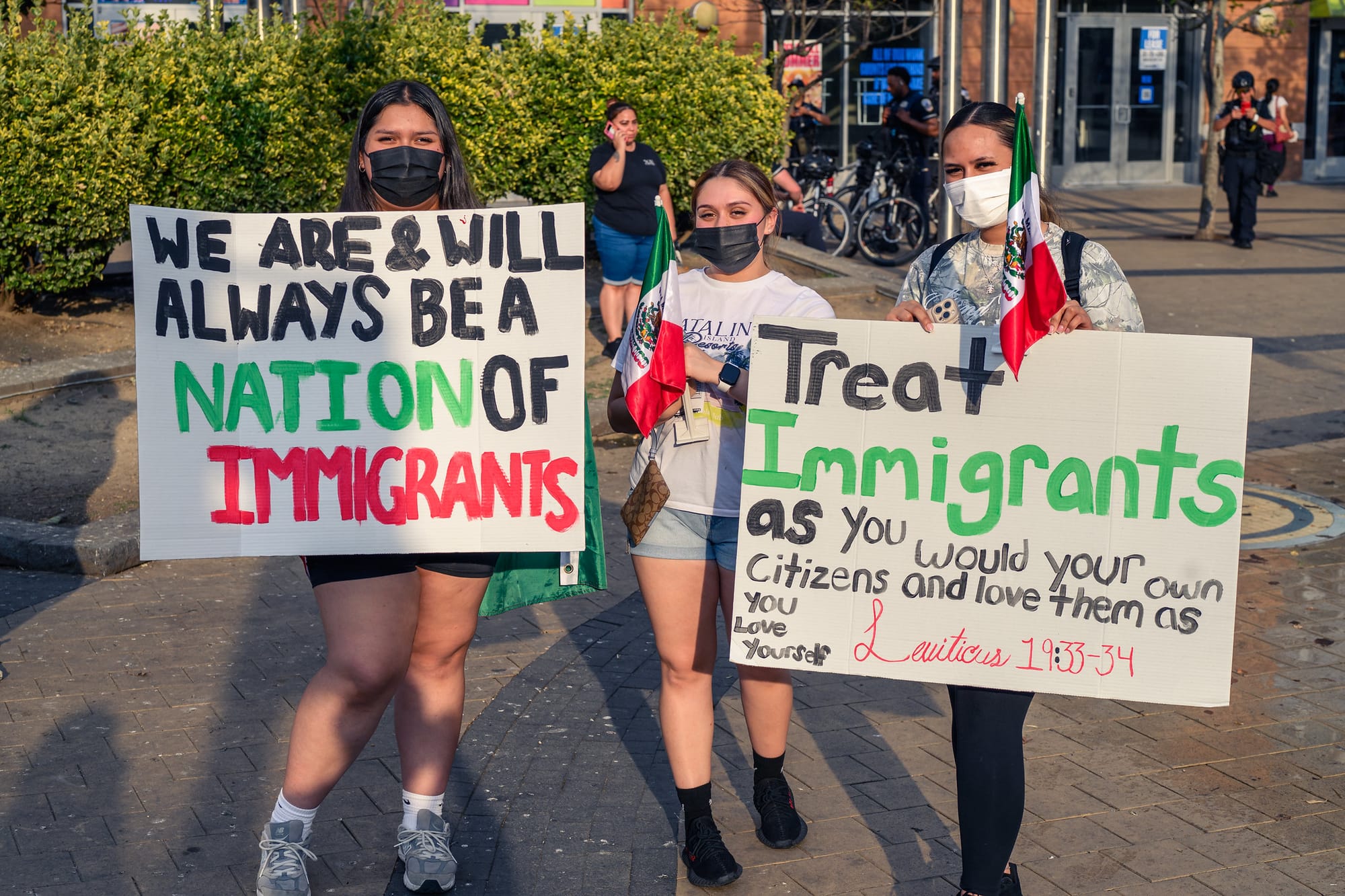 Young people holding signs in support of immigrants.