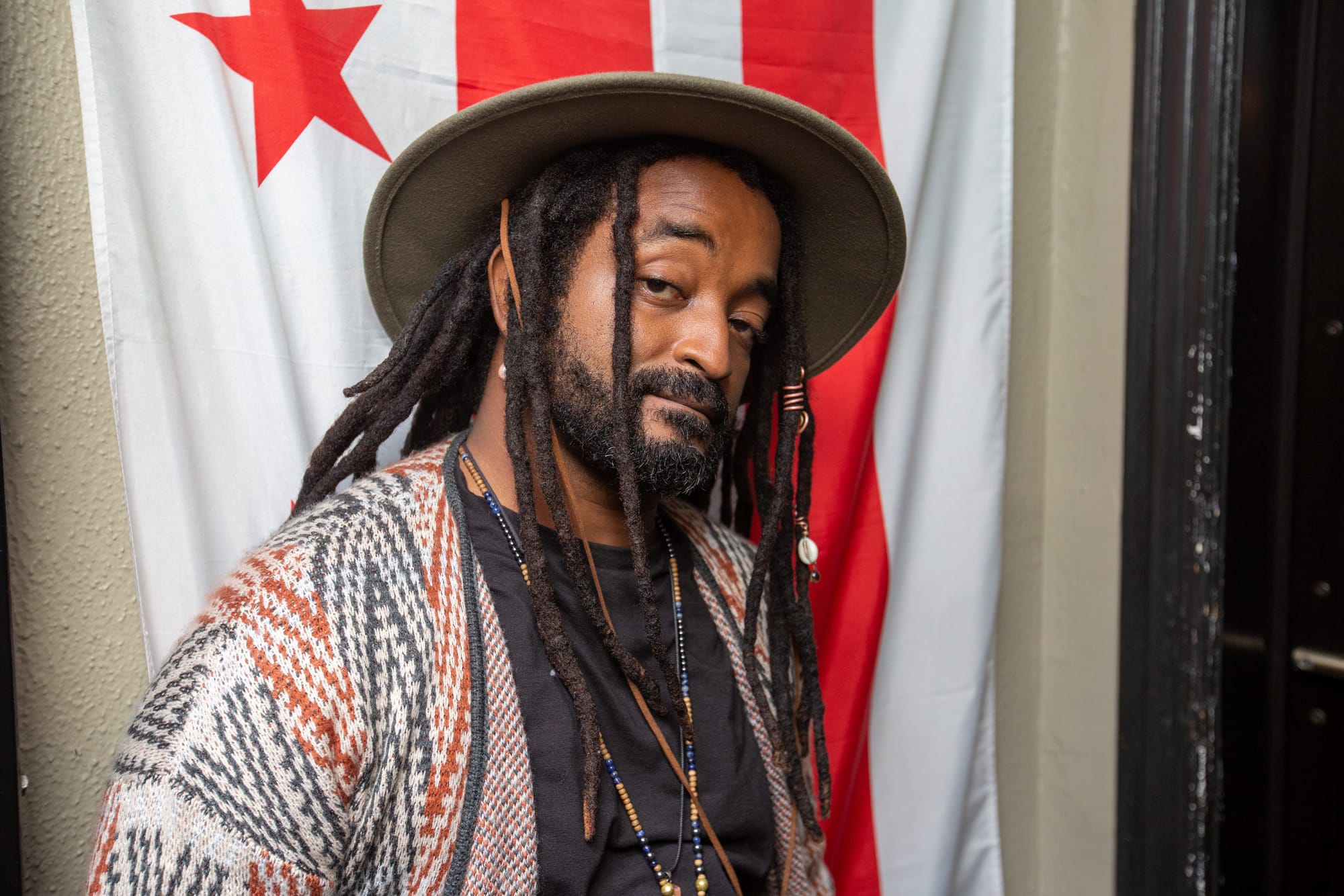 Photo of Dwayne standing in front of a DC flag