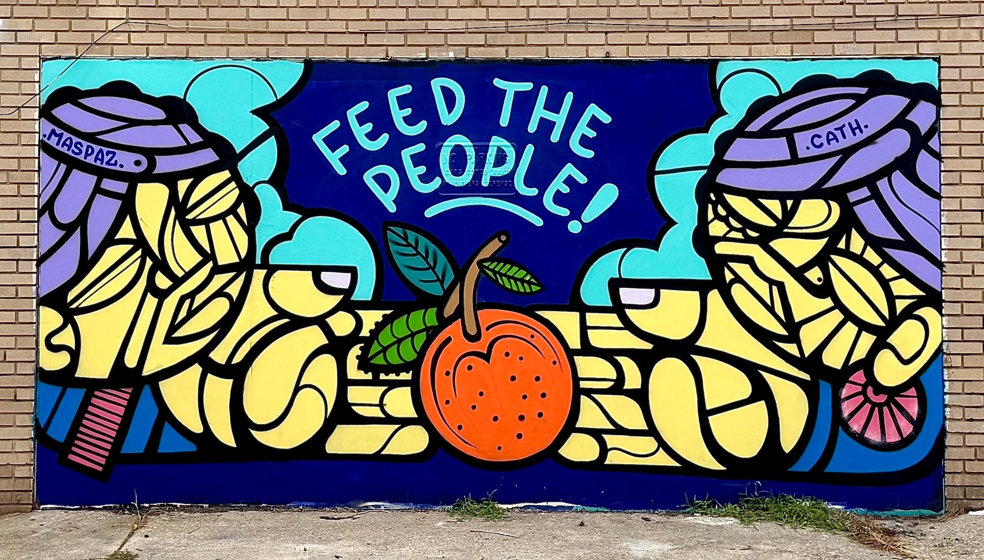 A colorful mural on a brick wall that reads Feed The People 