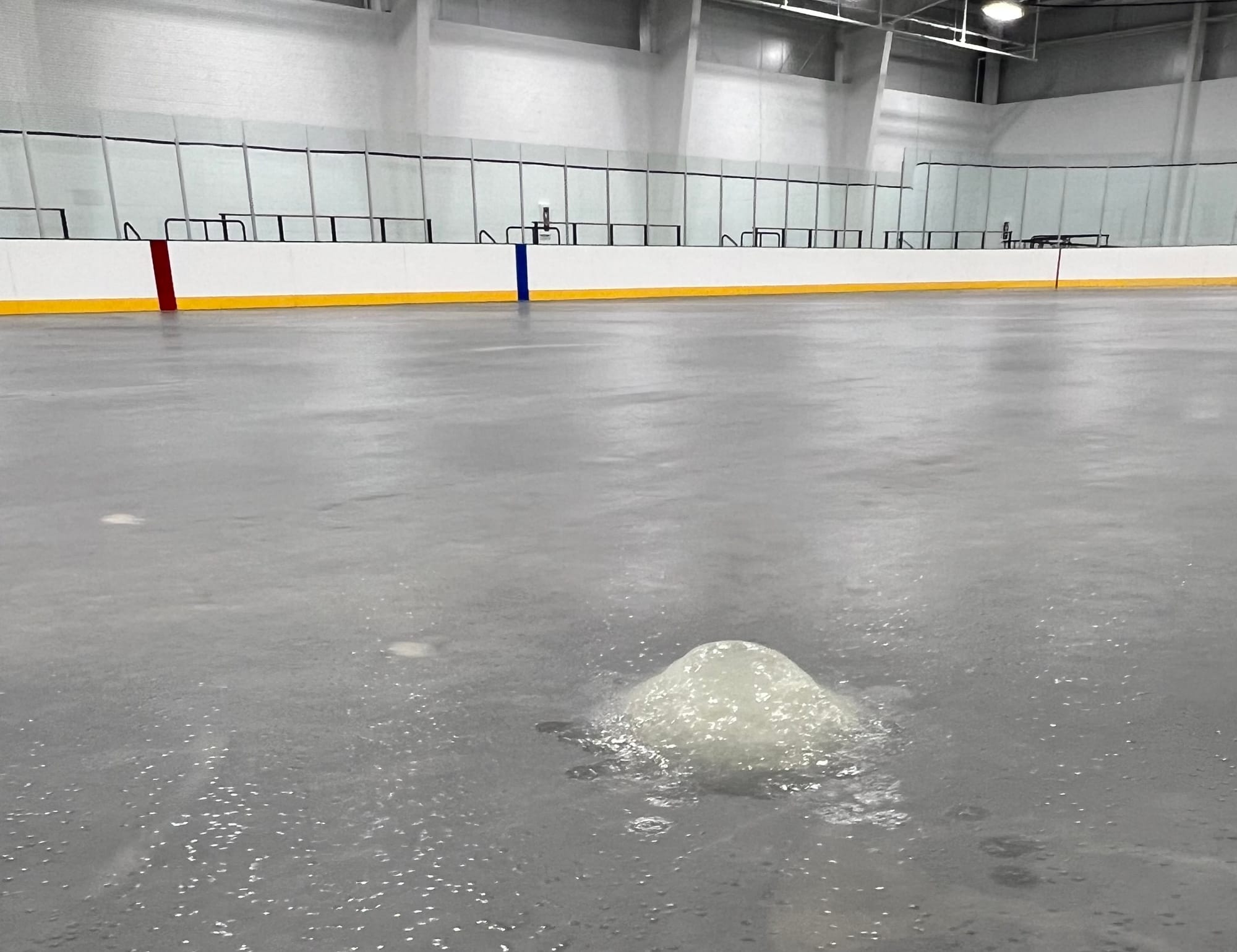 An ice rink with a large mound of ice in the middle.
