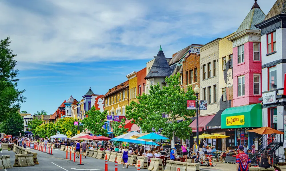 A view of streateries on 18th street on a sunny day, with crowds walking around