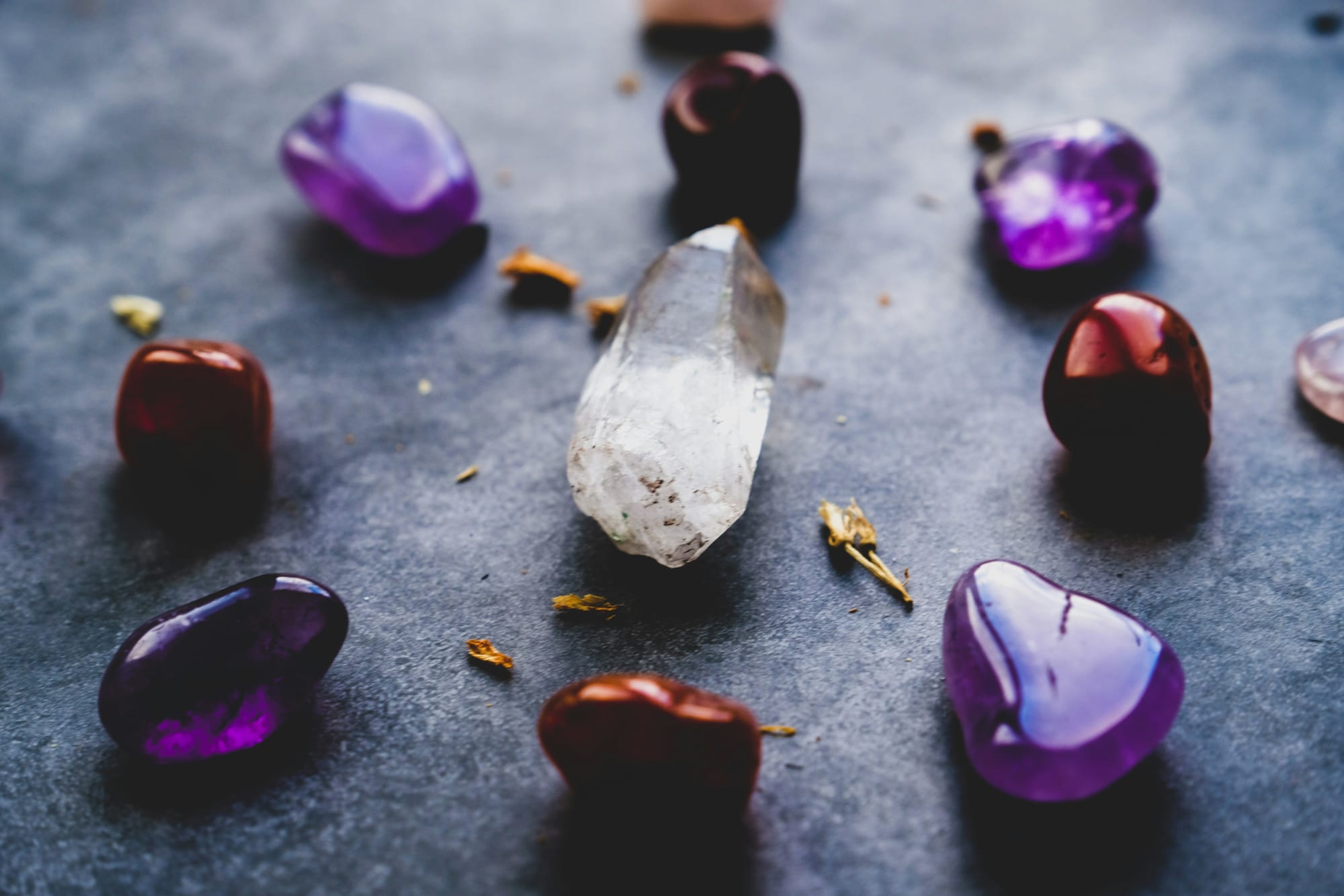 A crystal surrounded by red and purple shiny stones.