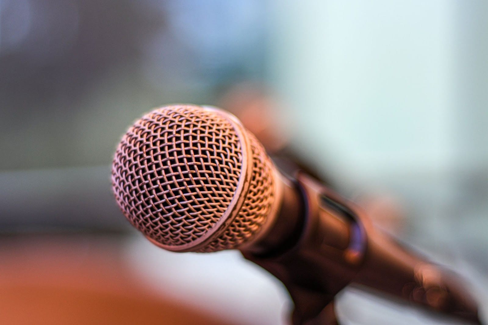 A closeup of a microphone with a blurred background.