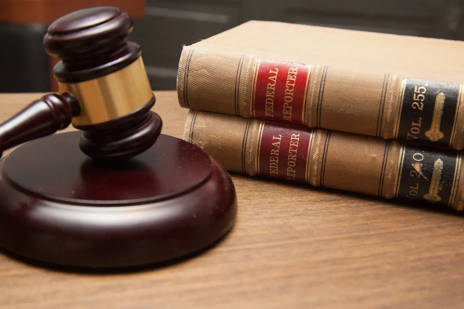 A judge's gavel next to a stack of two law books.
