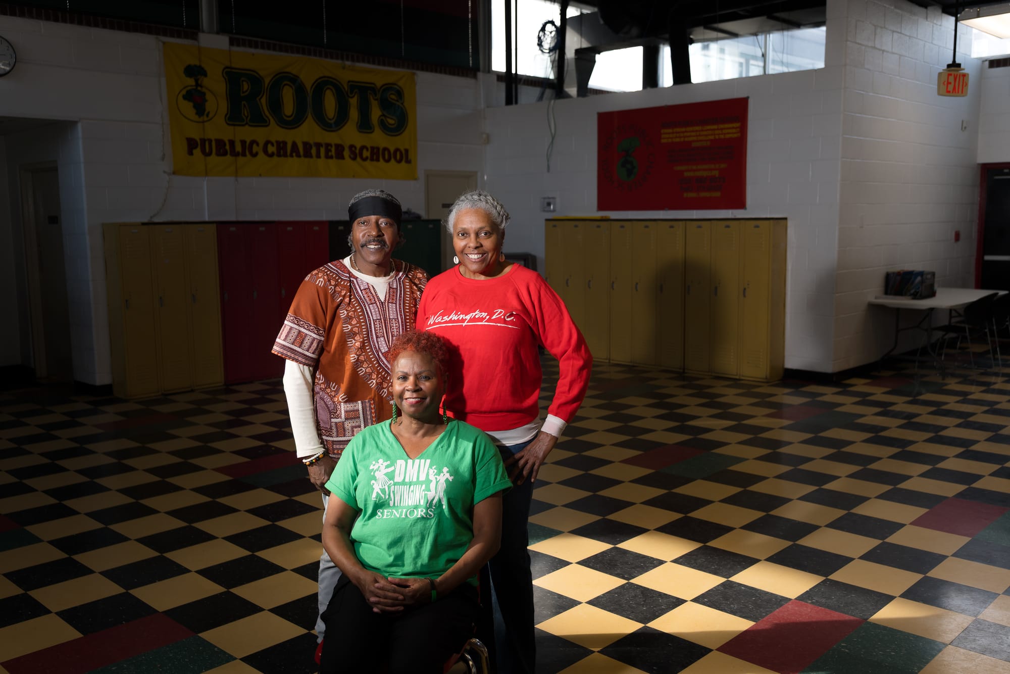 A photograph of three adults on a checkered dance floor.