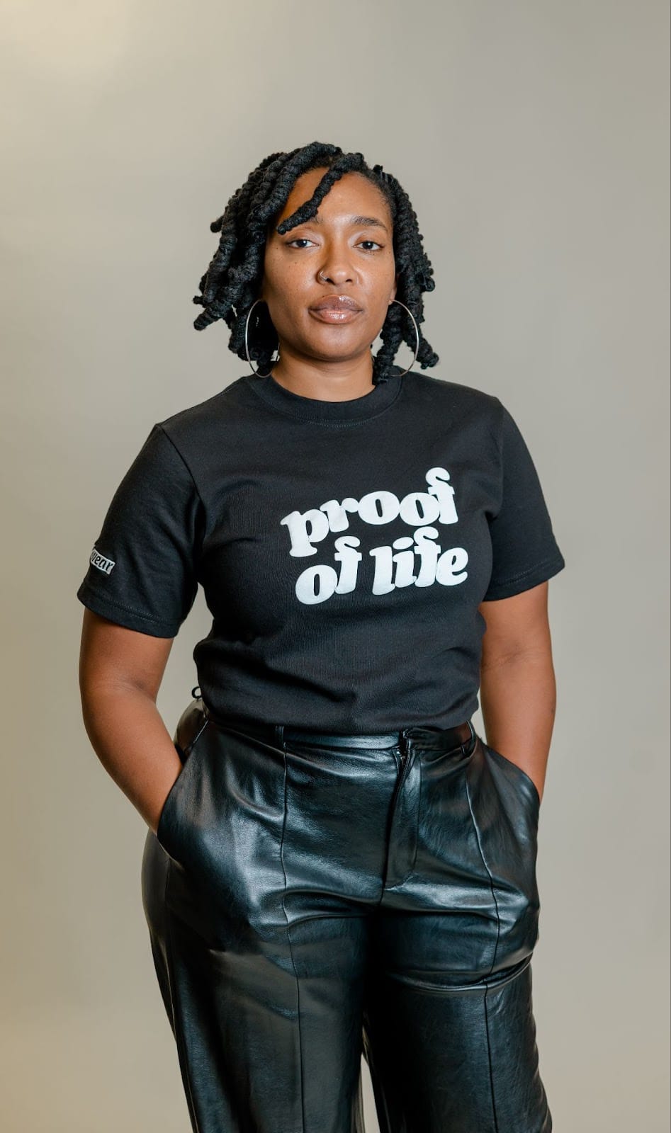A portrait of Imani Shanklin Roberts wearing a shirt that reads "Proof of Life"