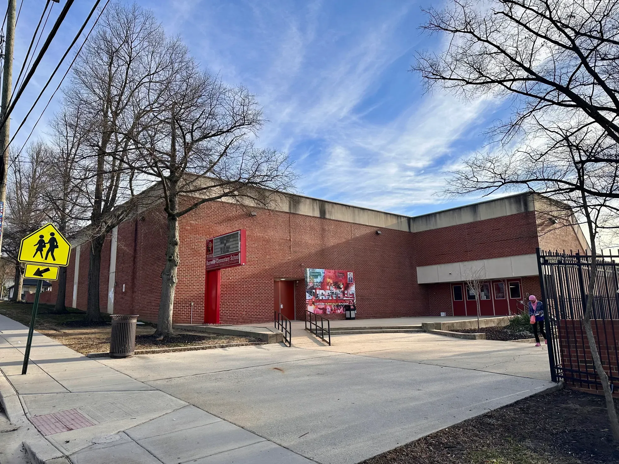 A boxy school building under a blue sky 