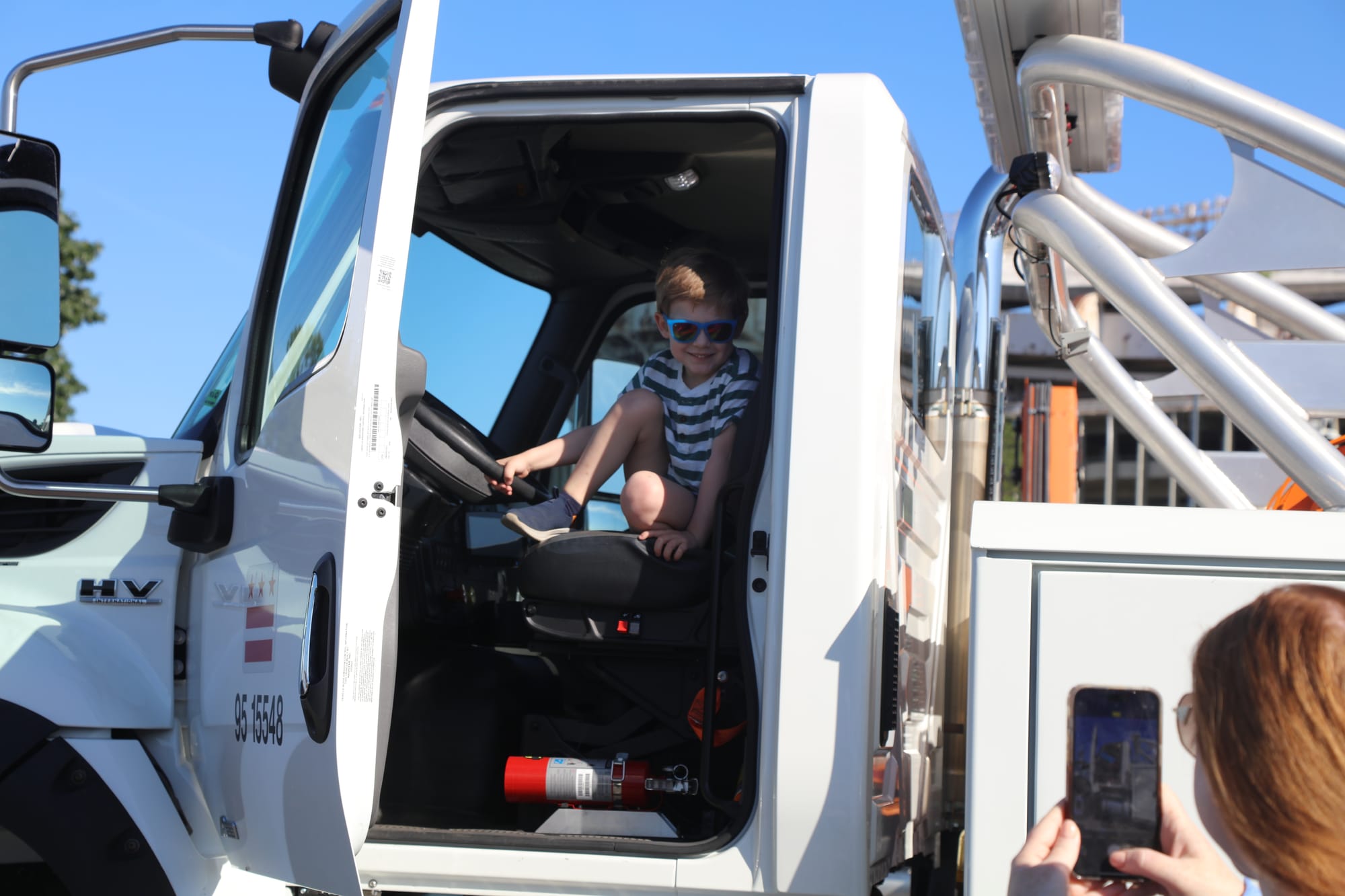A child poses for a photo inside a truck.