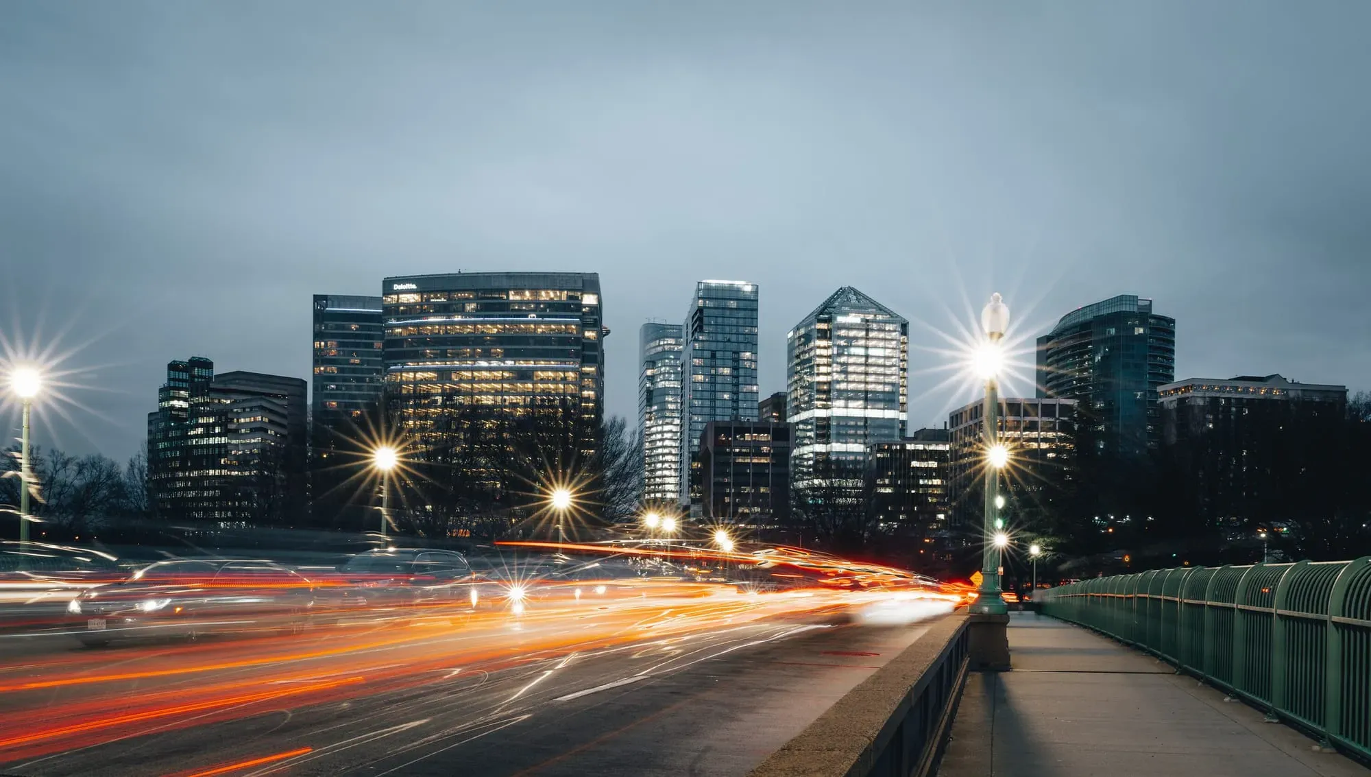 An image of blurry car lights on a busy road with a view of Arlington.