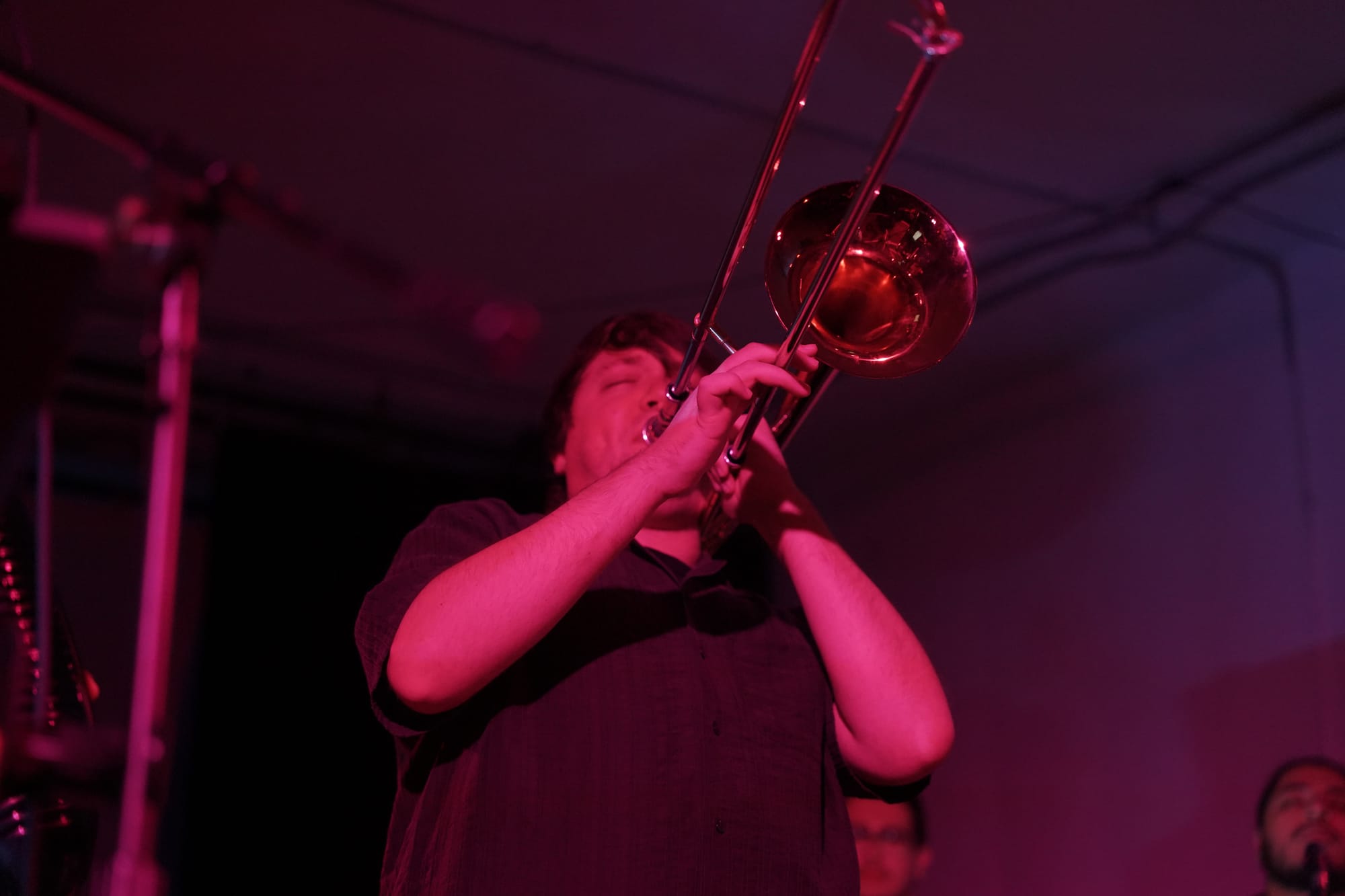 A pink-toned image of a trombone player