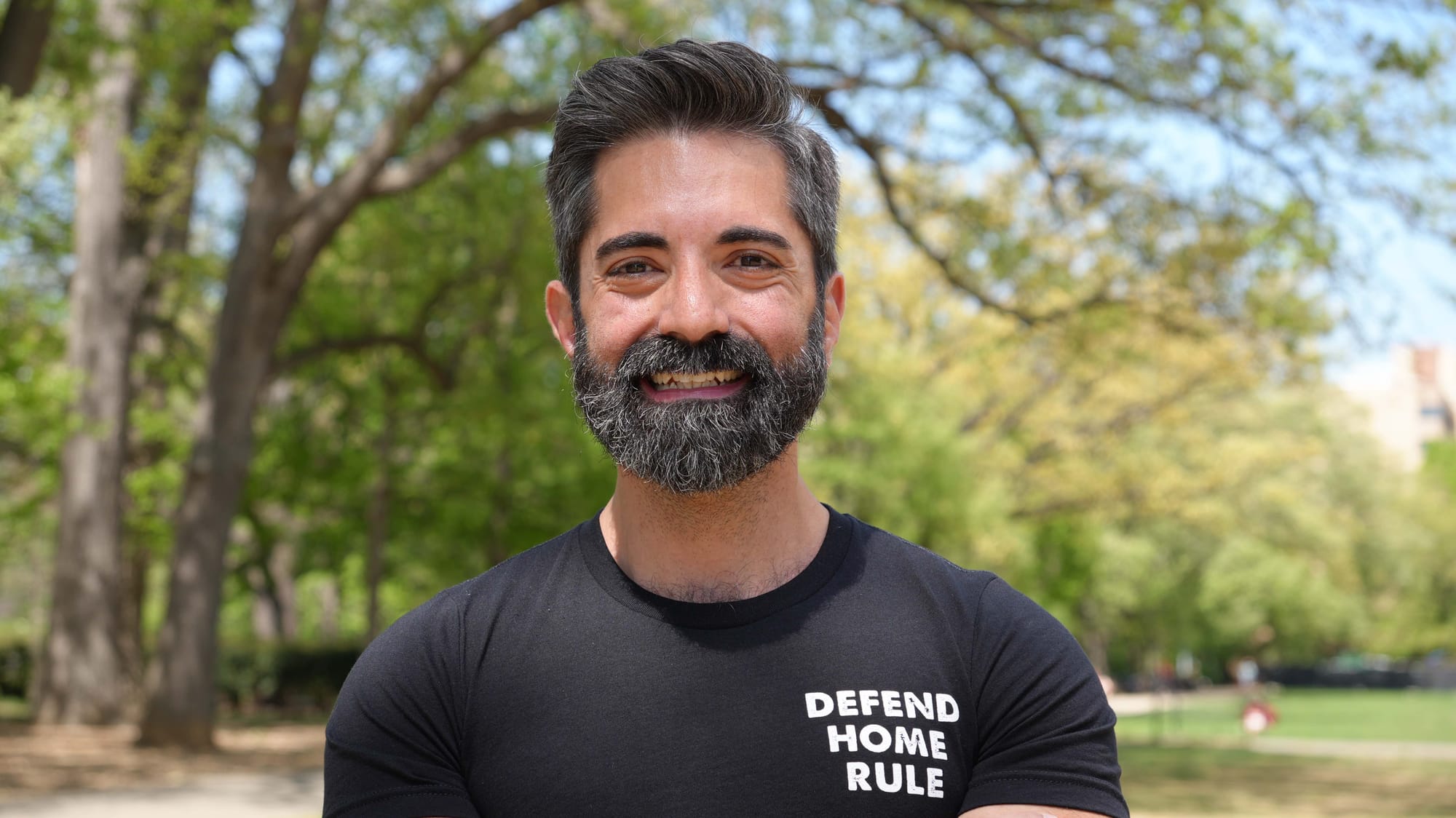 A photo of Miguel Trindade Deramo smiling at the camera in Malcolm X Park.