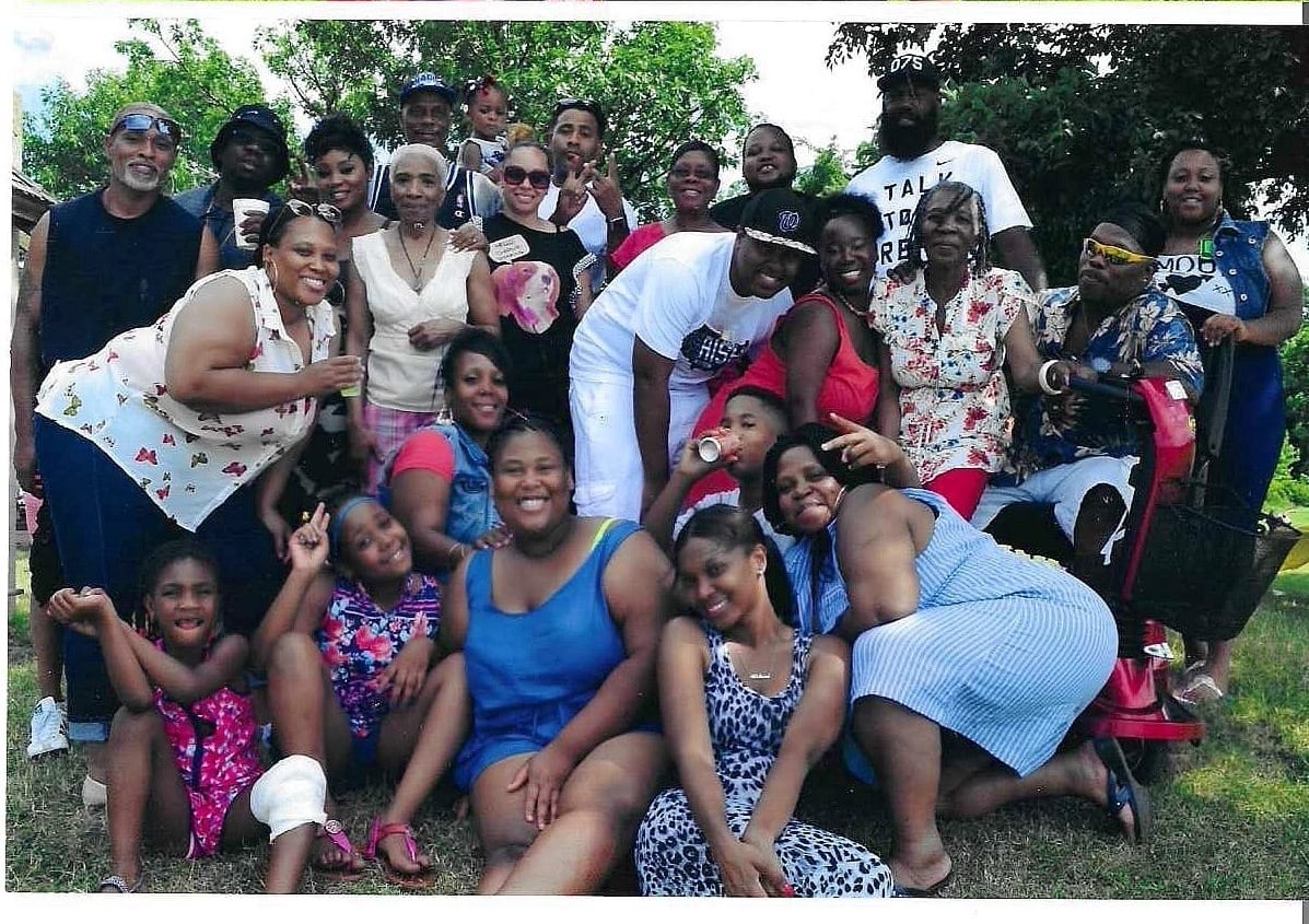 A group photo of family members posing at a park.