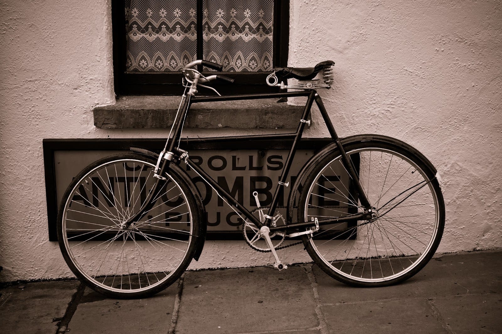 An old-fashioned bicycle outside a window.