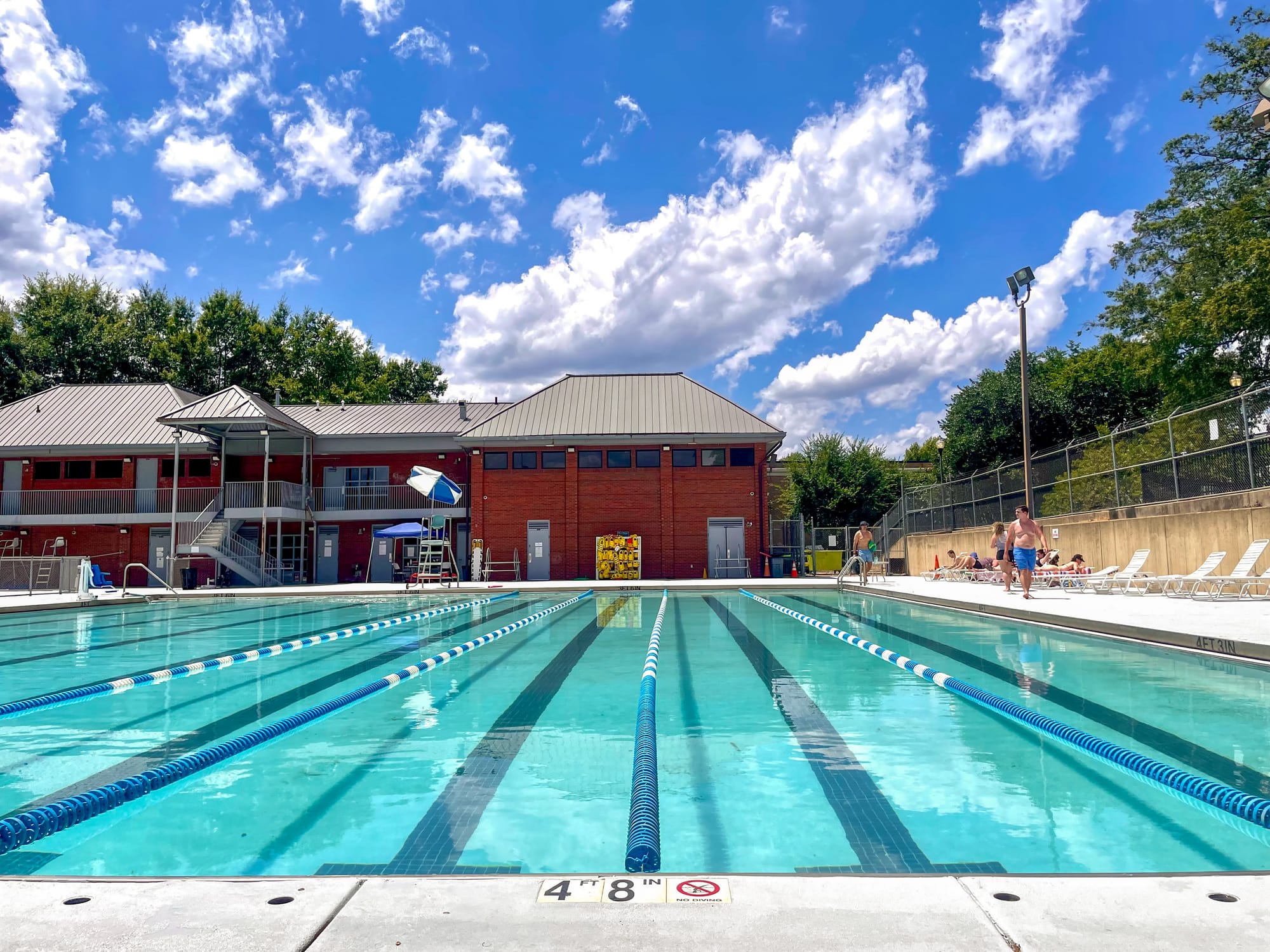 An outdoor pool under a bright blue sky.